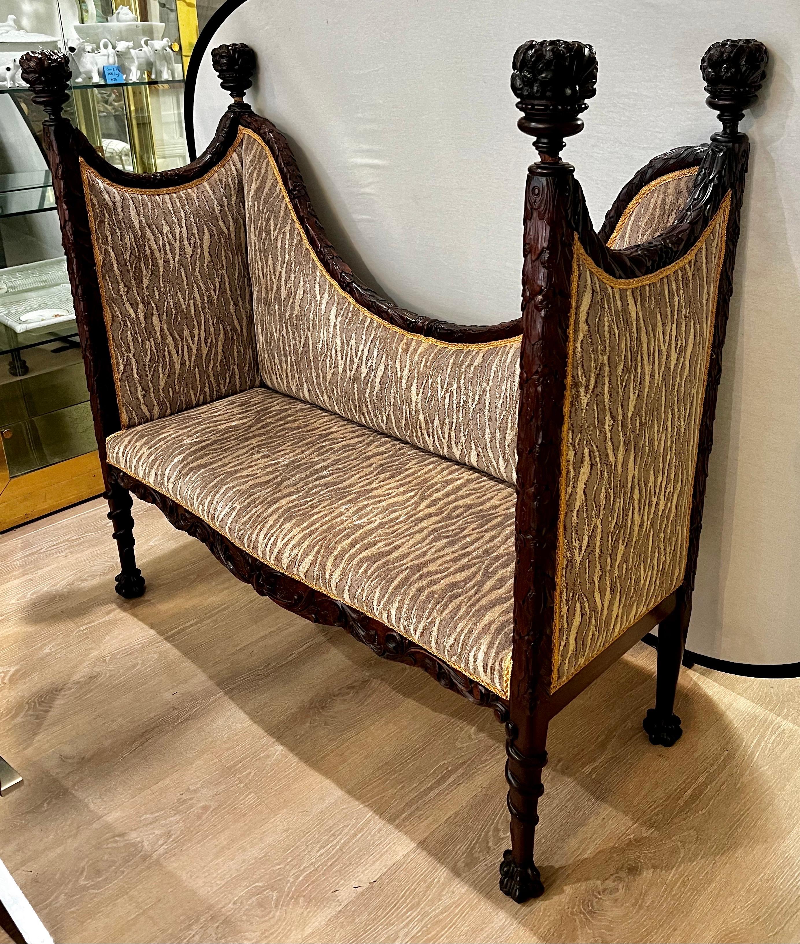 Ornately carved mahogany high back settee that has been reupholstered recently (about 2 years ago) in an updated luxurious fabric which perfectly plays off the elegant original frame.  Pictures do not do this piece justice!