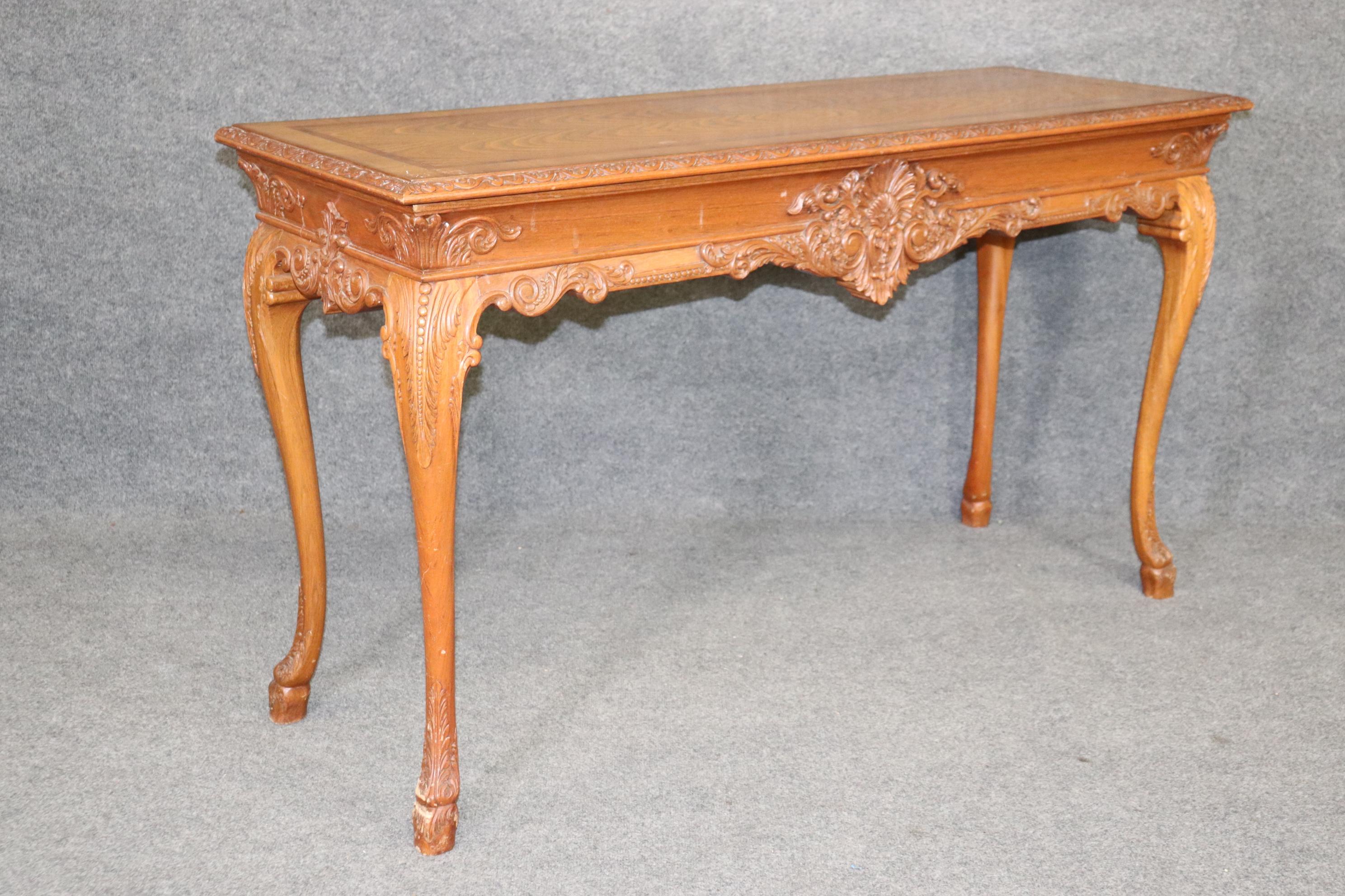 This is a beautiful European, probably English, extremely detailed and beautifully carved walnut Georgian table. The table can be used as a server or a console table. The carving and inlay is extremely well done and the condition is also good with