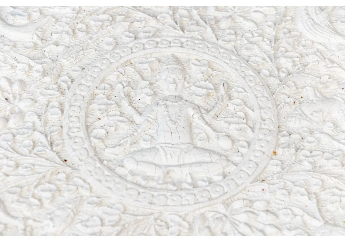 The intricately cast India pedestal accent table painted white with an octagonal top decorated with animals and figures in tree filled landscape panels with complementary pendant carved apron. Raised on a baluster form support with projecting fruits