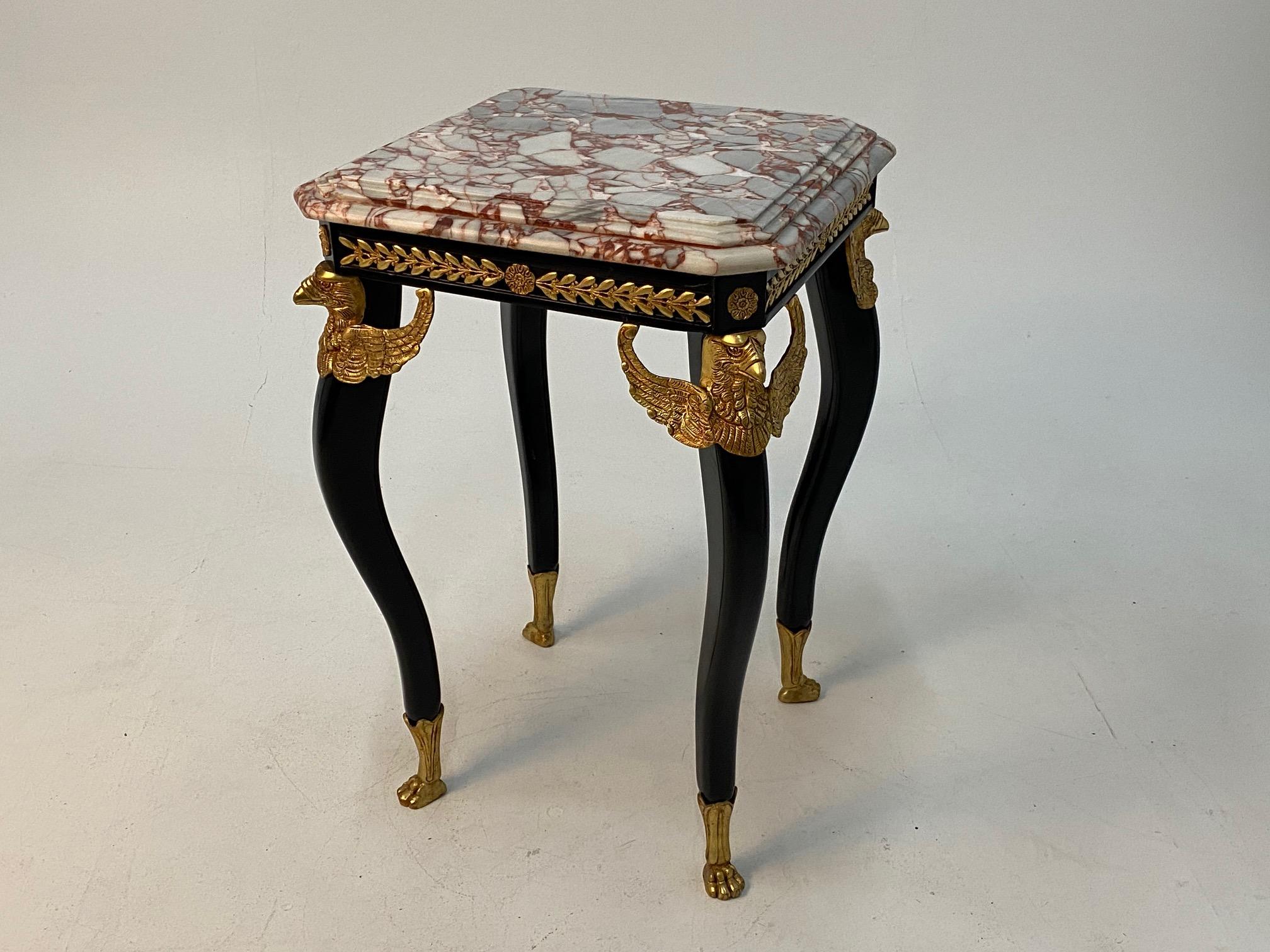 Elegant and very fancy Maison Jansen style French end table having ebonized and gilt bronze base with amazing eagle shaped mounts and paw feet. Top is a beautiful stepped marble with lively grain.