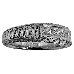 Bracelet en platine gravé avec sept diamants de taille Princesse sur le dessus.