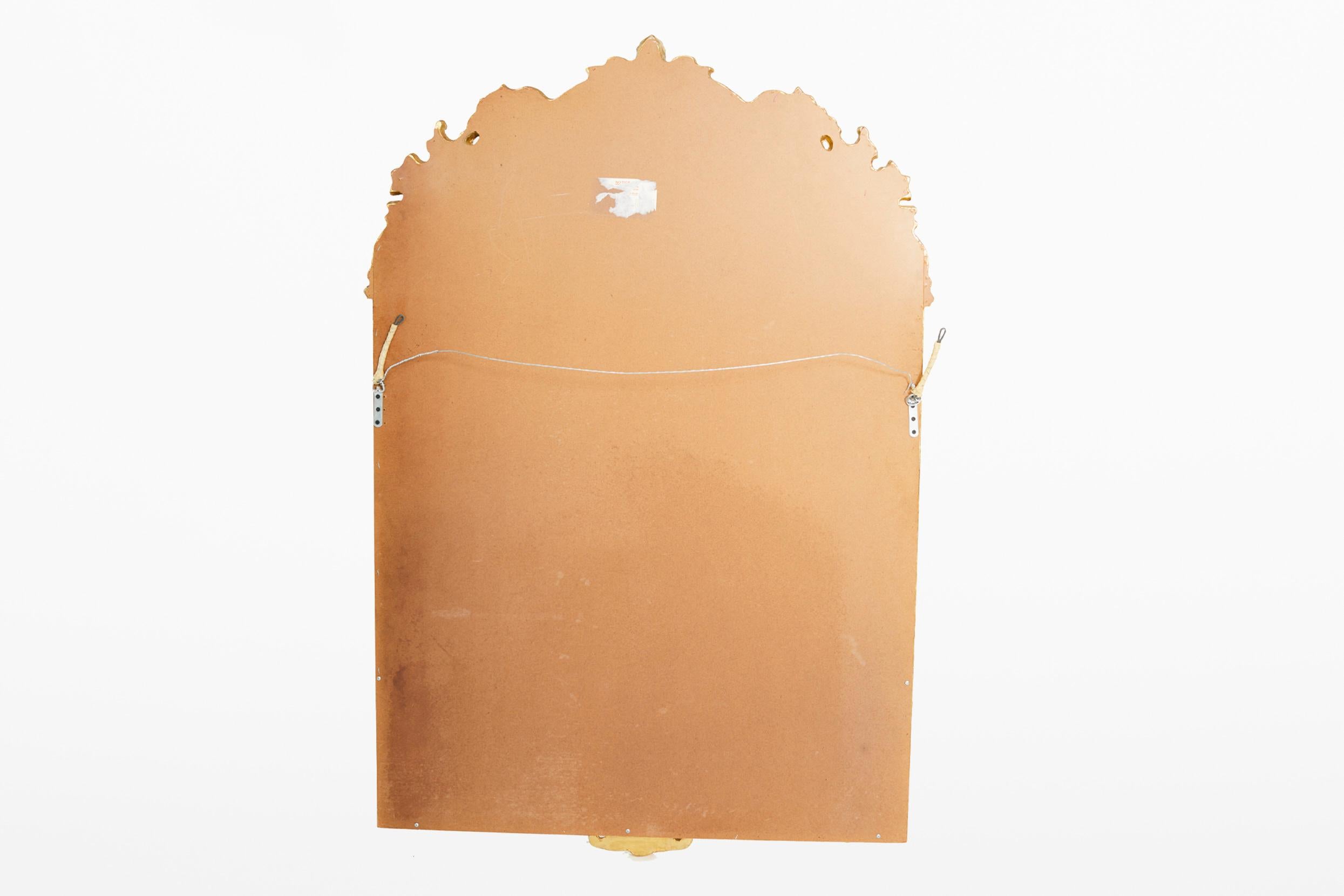Miroir suspendu dans un cadre en bois doré et orné en vente 1