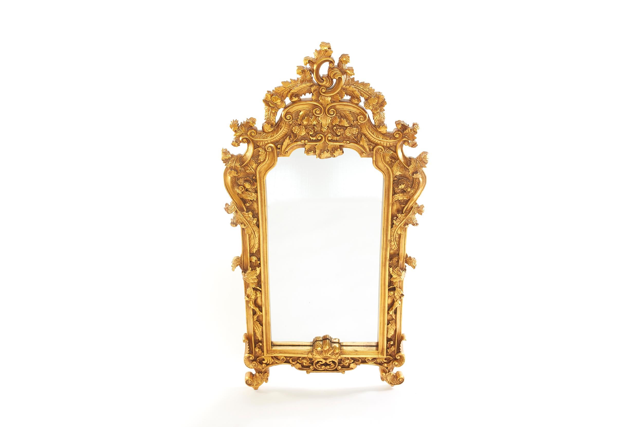 Paire de miroirs muraux suspendus biseautés, encadrés en bois doré orné de motifs sculptés à la main. Le miroir est en bon état. Usure mineure correspondant à l'âge/à l'utilisation. Le cadre en bois doré mesure 60 pouces de haut x 31 pouces de large