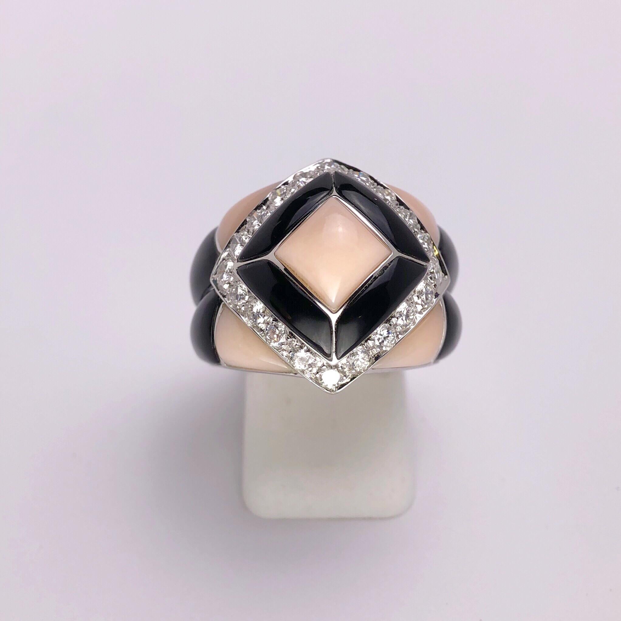 This stunning 18KT white gold ring was designed by renowned Italian Jewelers Oro Trend . It has a strong Art Deco influence. Hand carved geometric sections of baby pink coral and black onyx  grace this magnificent ring.The center section is tiered