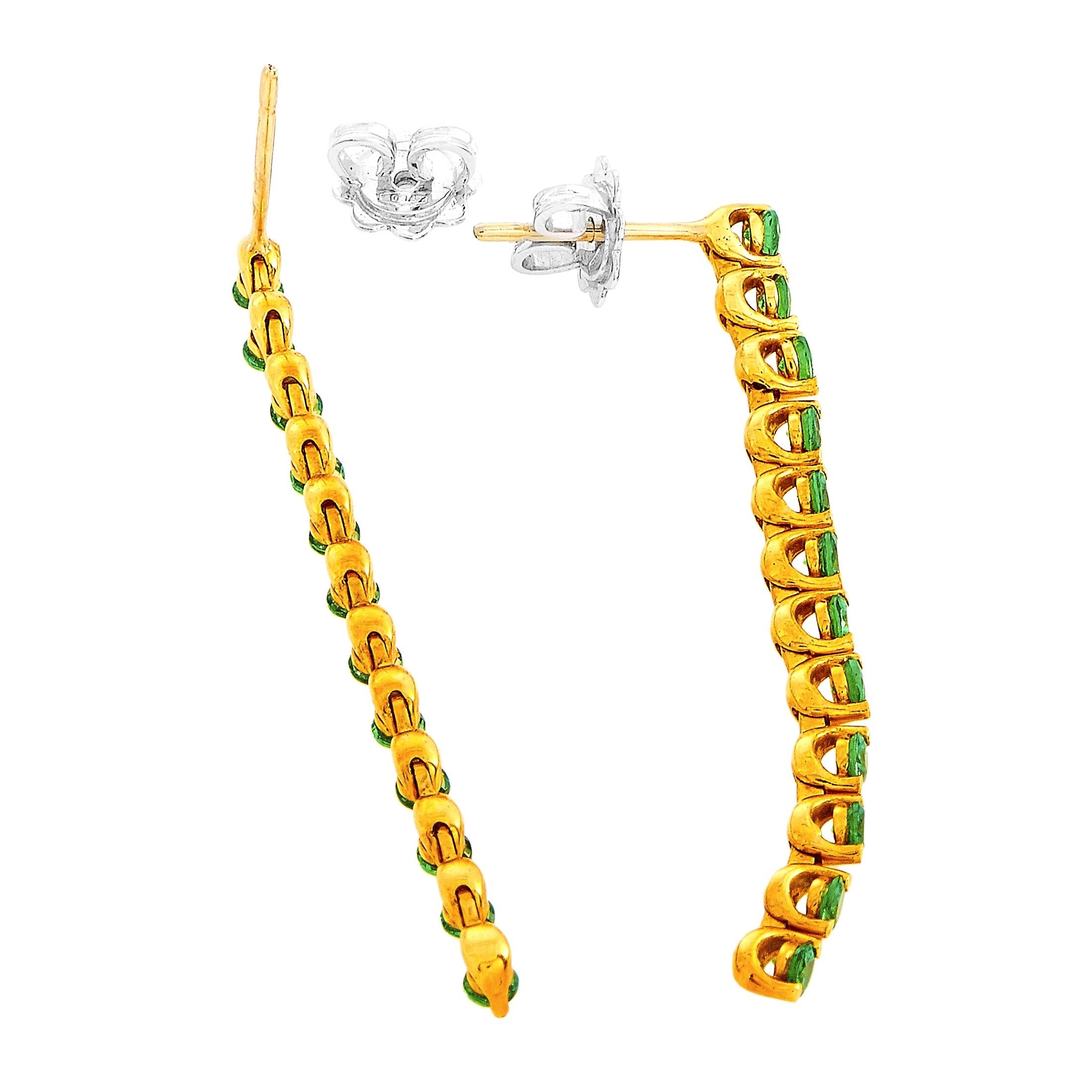 These Oro Trend earrings are made out of 18K yellow gold and tsavorites that total 1.00 carat. The earrings measure 2” in length and 0.15” in width and each of the two weighs 2.9 grams.

The pair is offered in brand new condition and includes a gift