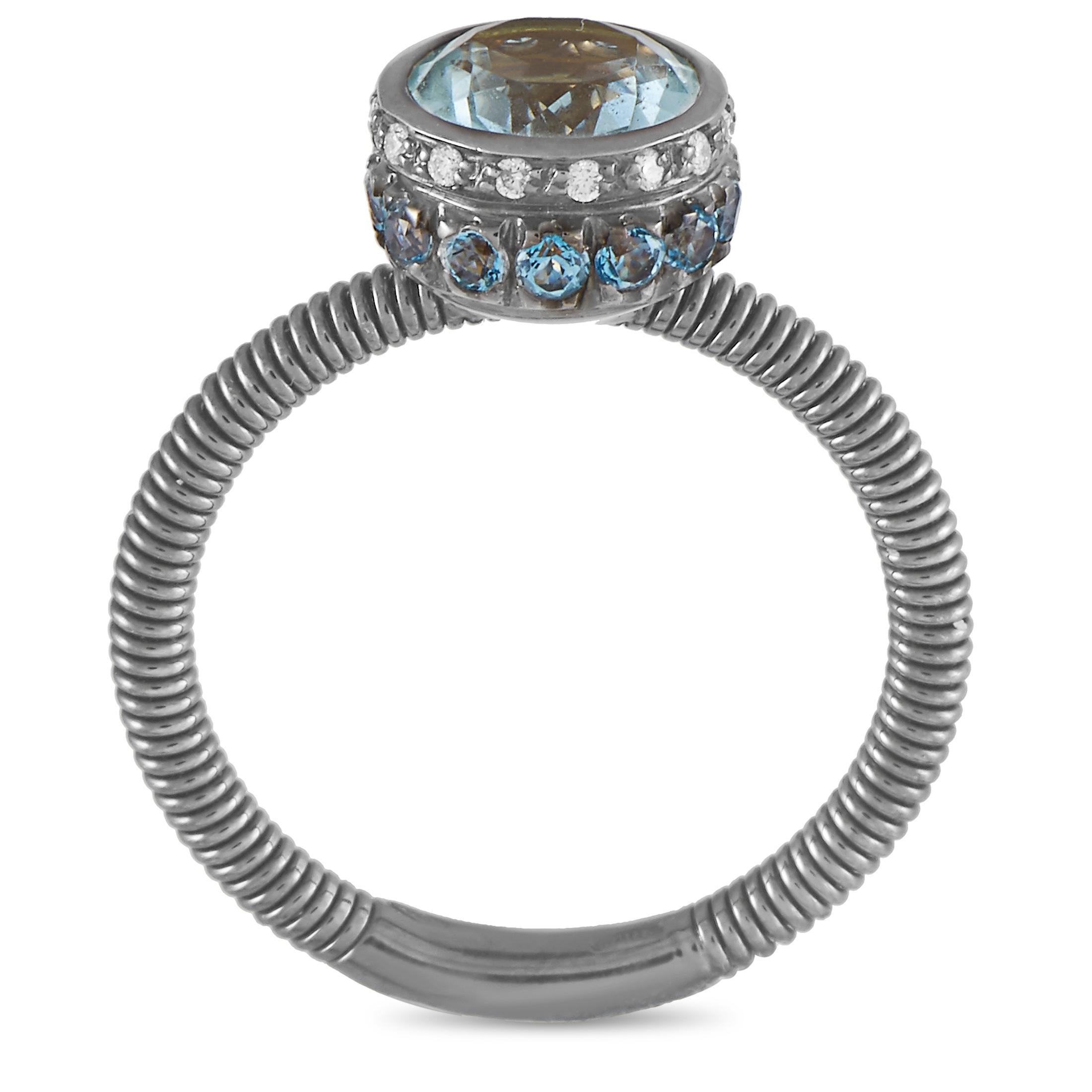 This Oro Trend ring is made of 18K white gold and weighs 4.2 grams, boasting band thickness of 2 mm and top height of 7 mm, while top dimensions measure 9 by 9 mm. The ring is embellished with aquamarine and topaz stones and a total of 0.10 carats