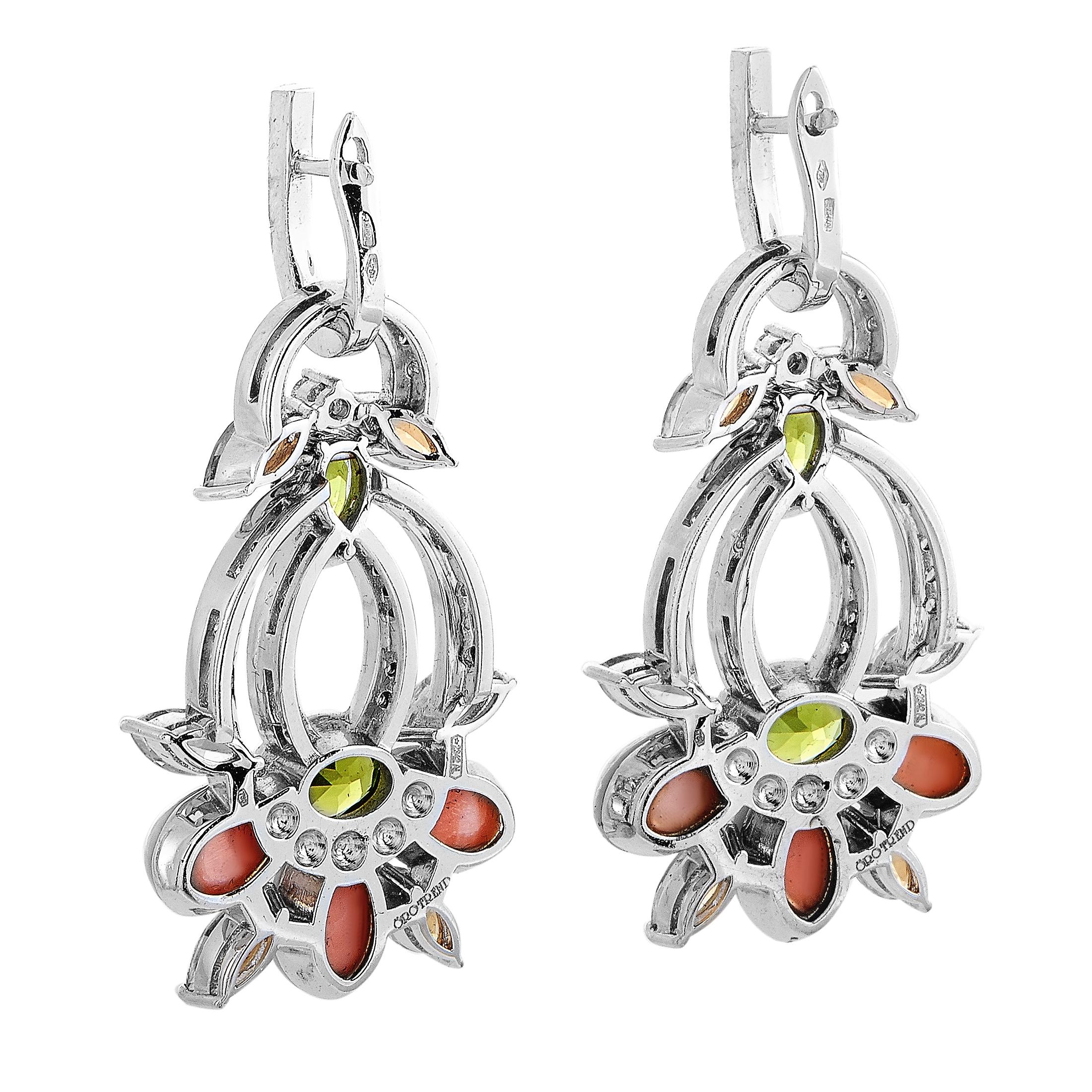 These Oro Trend earrings are crafted from 18K white gold and embellished with corals, peridot and imperial topaz stones, and with a total of 1.10 carats of diamonds. The earrings measure 2” in length and 1” in width and each of the two weighs 11.5