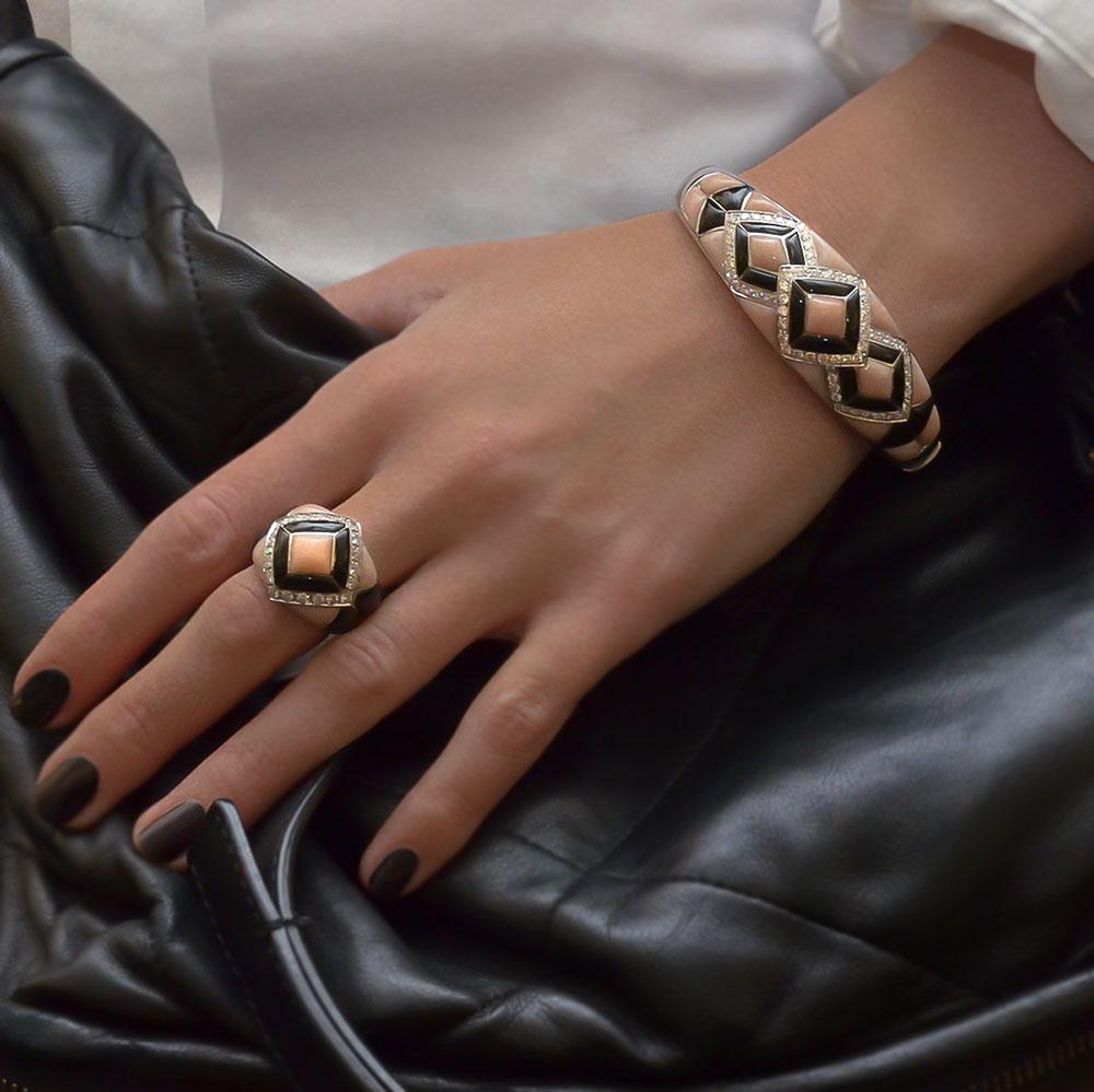 Dieses atemberaubende Armband aus 18-karätigem Weißgold, entworfen vom renommierten italienischen Juwelier Oro Trend, hat einen starken Art-déco-Einfluss. Handgeschnitzte geometrische Abschnitte aus rosa Koralle und schwarzem Onyx sind in einen