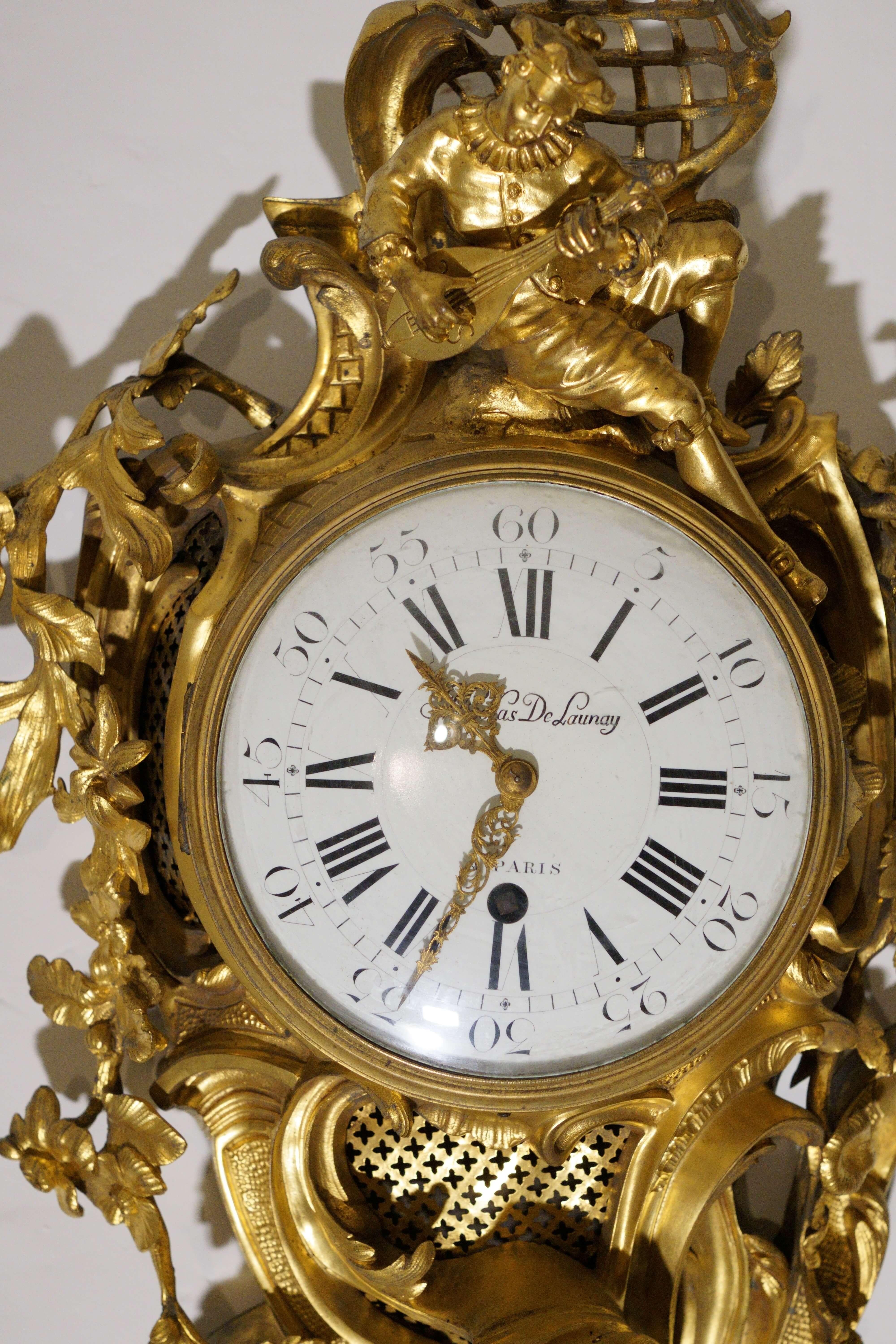Impressive Louis XV period cartel clock by Nicolas De Launay, first half of the 18th century.
The case, with rocaille motifs of leaves and flowers, in mercury-gilt bronze, is decorated with a character from the commedia dell'arte, Pierrot, playing a