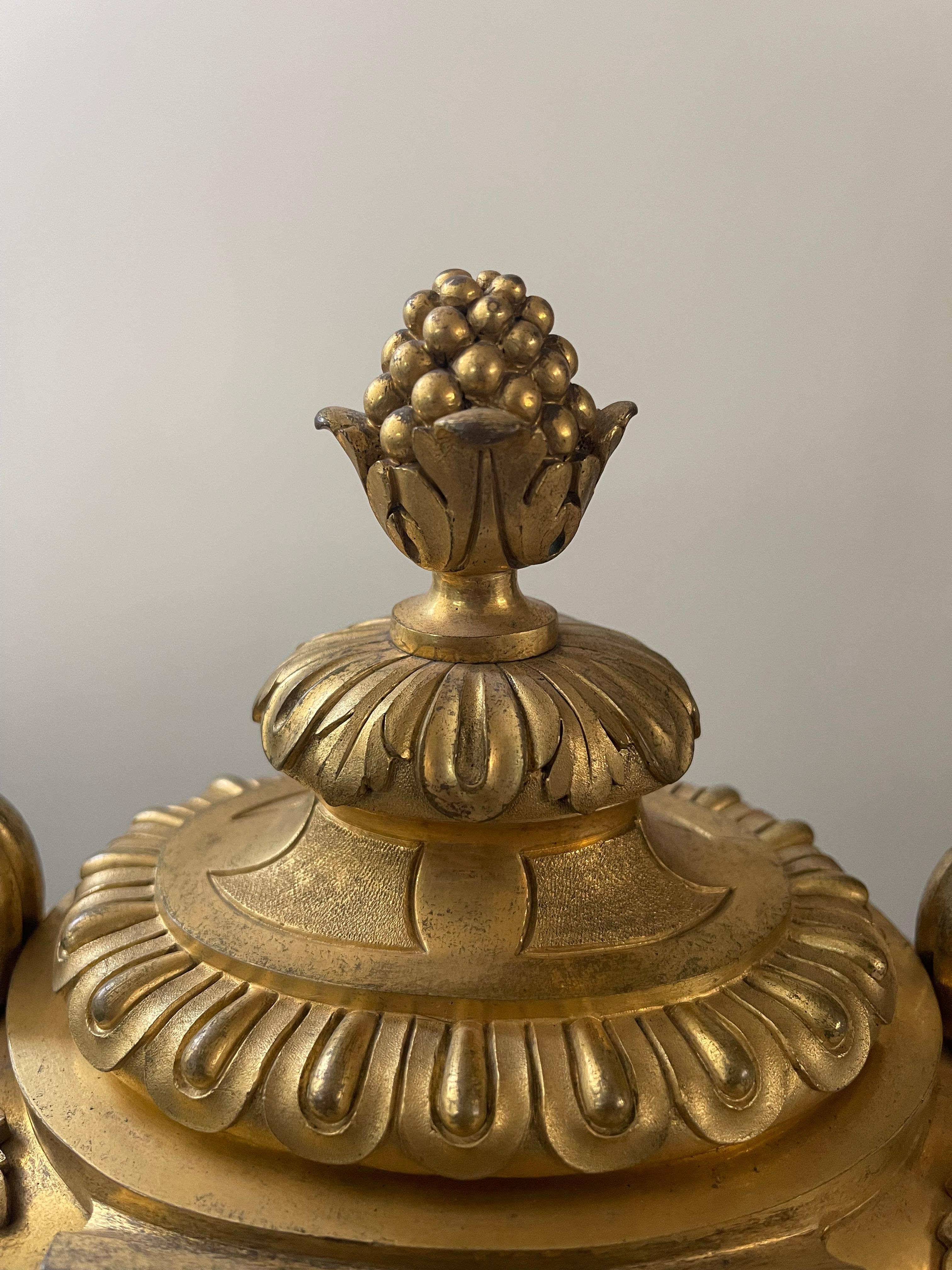 Magnifico orologio da tavolo in bronzo dorato, realizzato in stile Luigi XVI, firmato Le Faucheur – A Paris, noto orologiaio francese. Il pezzo, dalle linee eleganti e riccamente decorate, si distingue per la sua forma a vaso con anse laterali