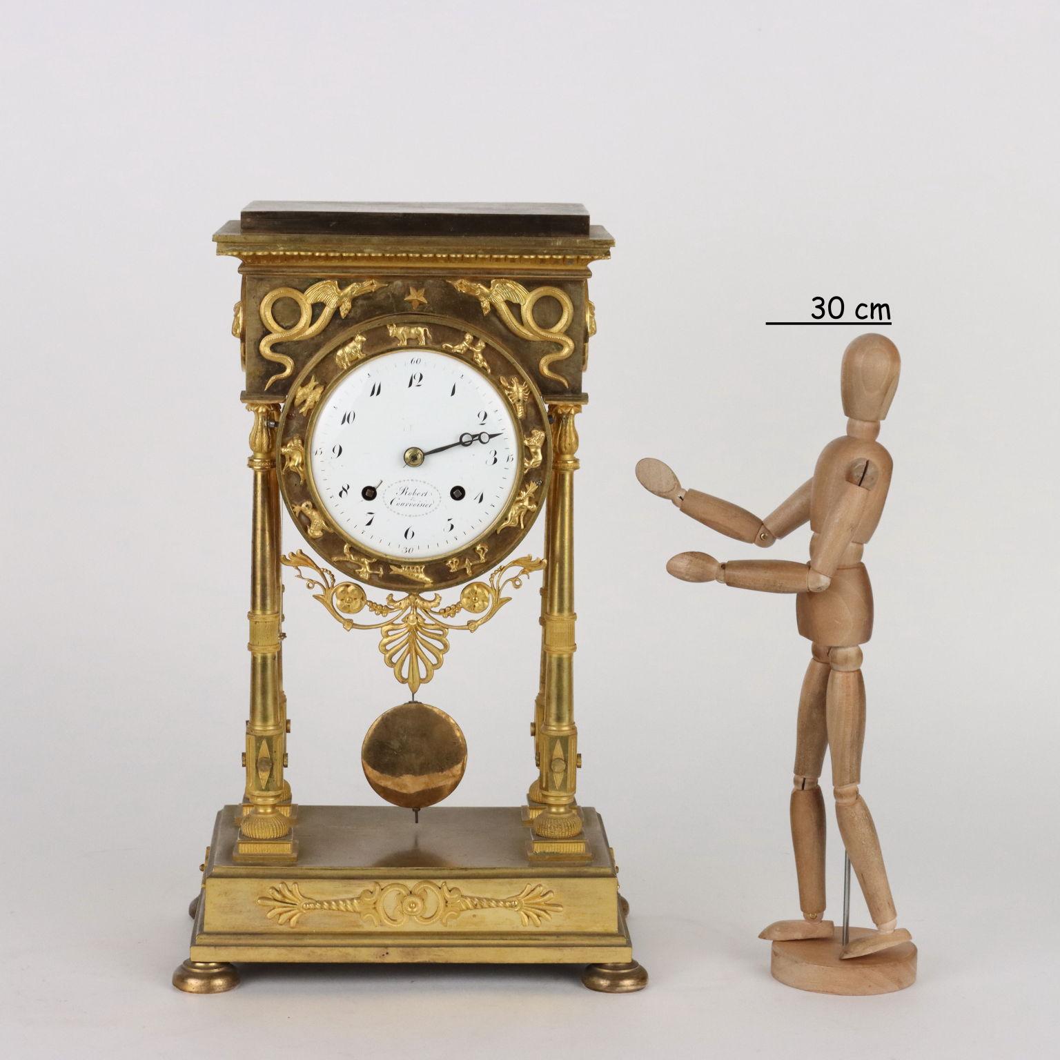 Robert & Courvoisier gilt bronze temple table clock, finely chiseled and engraved. Decorations with lion heads, winged dragons, and plant motifs. The enameled metal display with Arabic numeral hours and minutes is held by a gilded bronze frame with