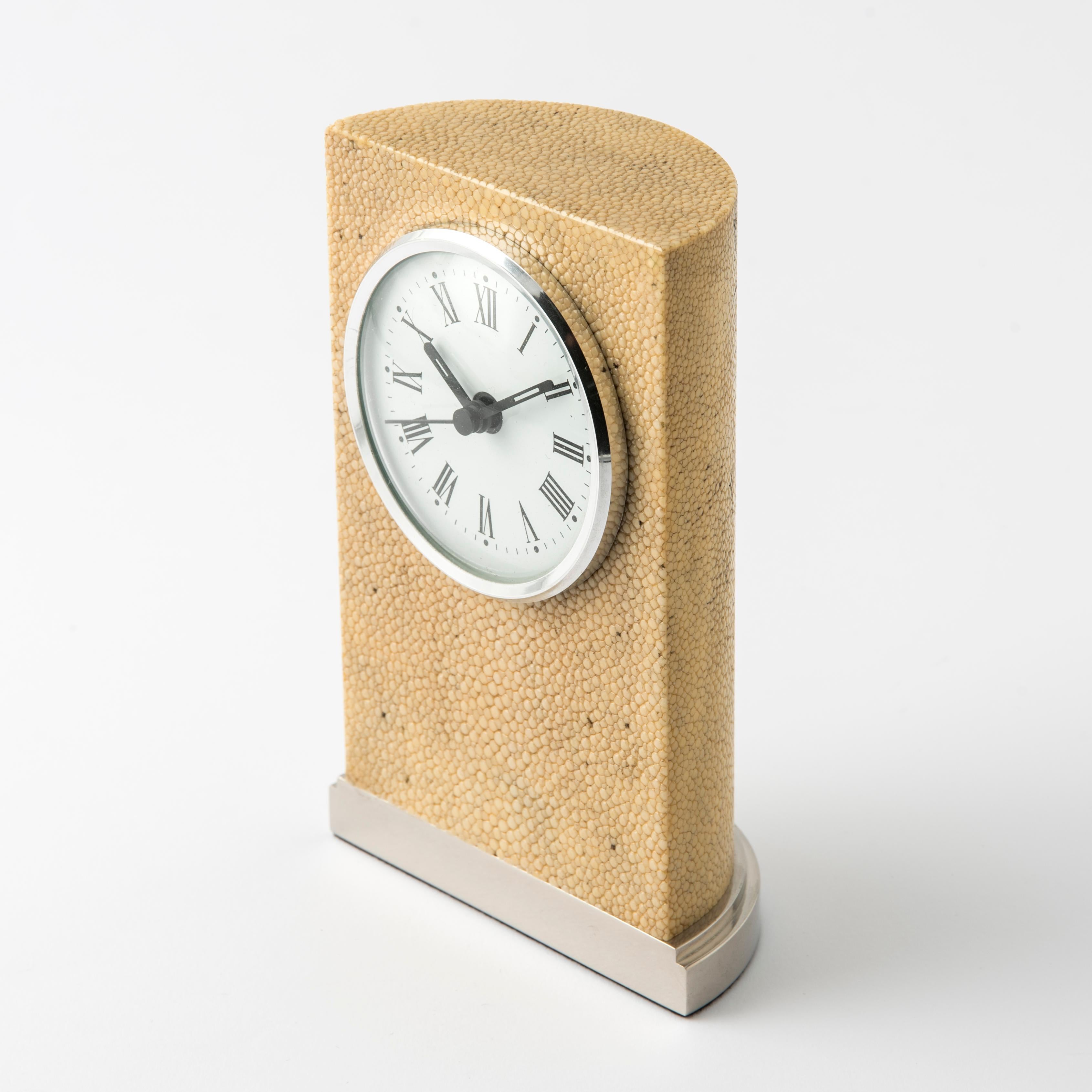 Diese luxuriöse Tischuhr ist ein perfektes Gleichgewicht zwischen klassischem Stil und zeitgenössischem Design und ist ein Ausdruck von Raffinesse und Exklusivität. Inspiriert von romanischen Säulen, wurde das essentielle geometrische Design von dem