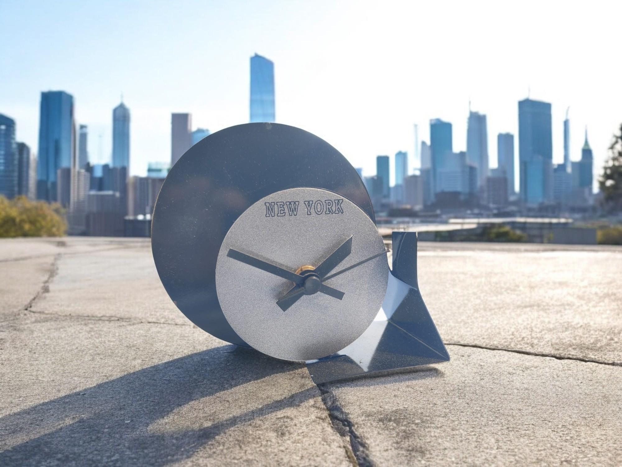Radical Memphis style table clock, produced in the early 1980s, postmodern, made of lacquered metal, with red circular dial on black background.

It is part of a stock of clocks from a store depot that was closed decades ago and miraculously