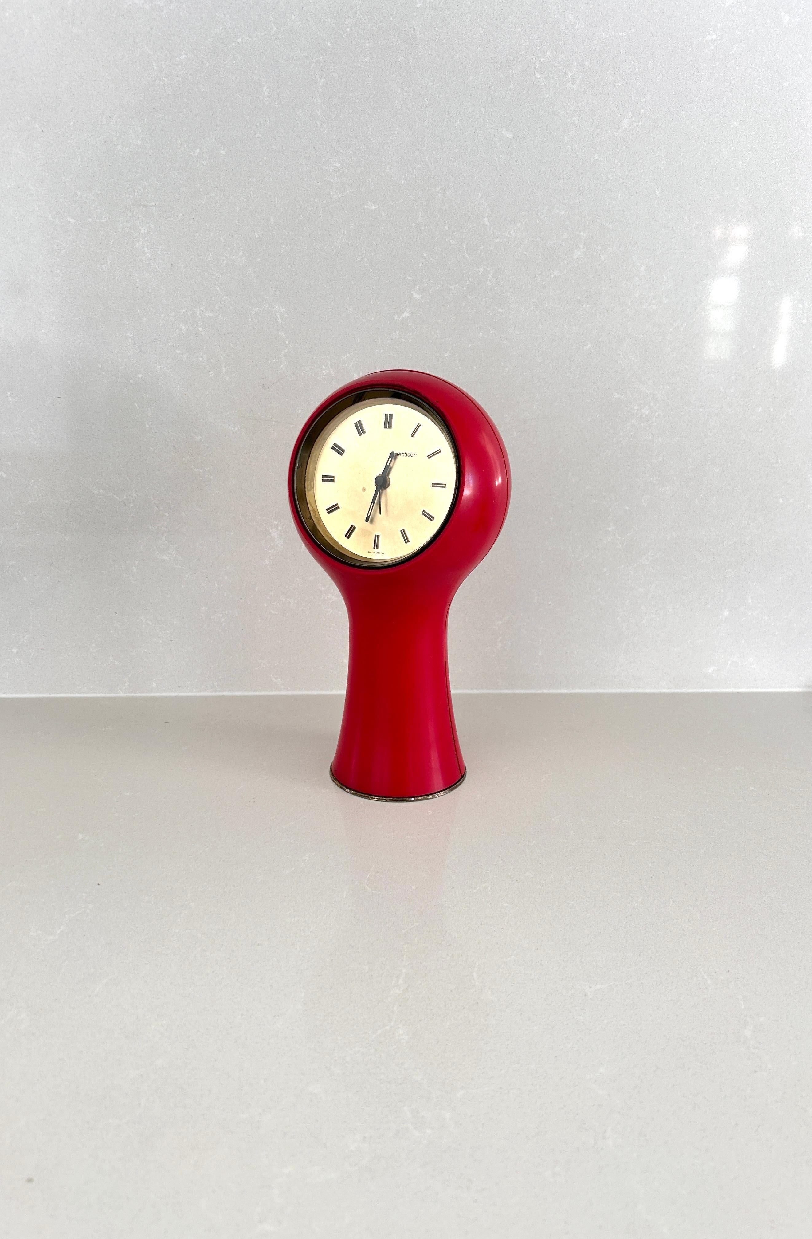 Orologio da tavolo disegnato da Angelo Mangiarotti e Bruno Morassutti nel 1956 per l’azienda svizzera Le Porte-Echappement Universel.

Struttura in plastica rossa, movimento a batteria.
