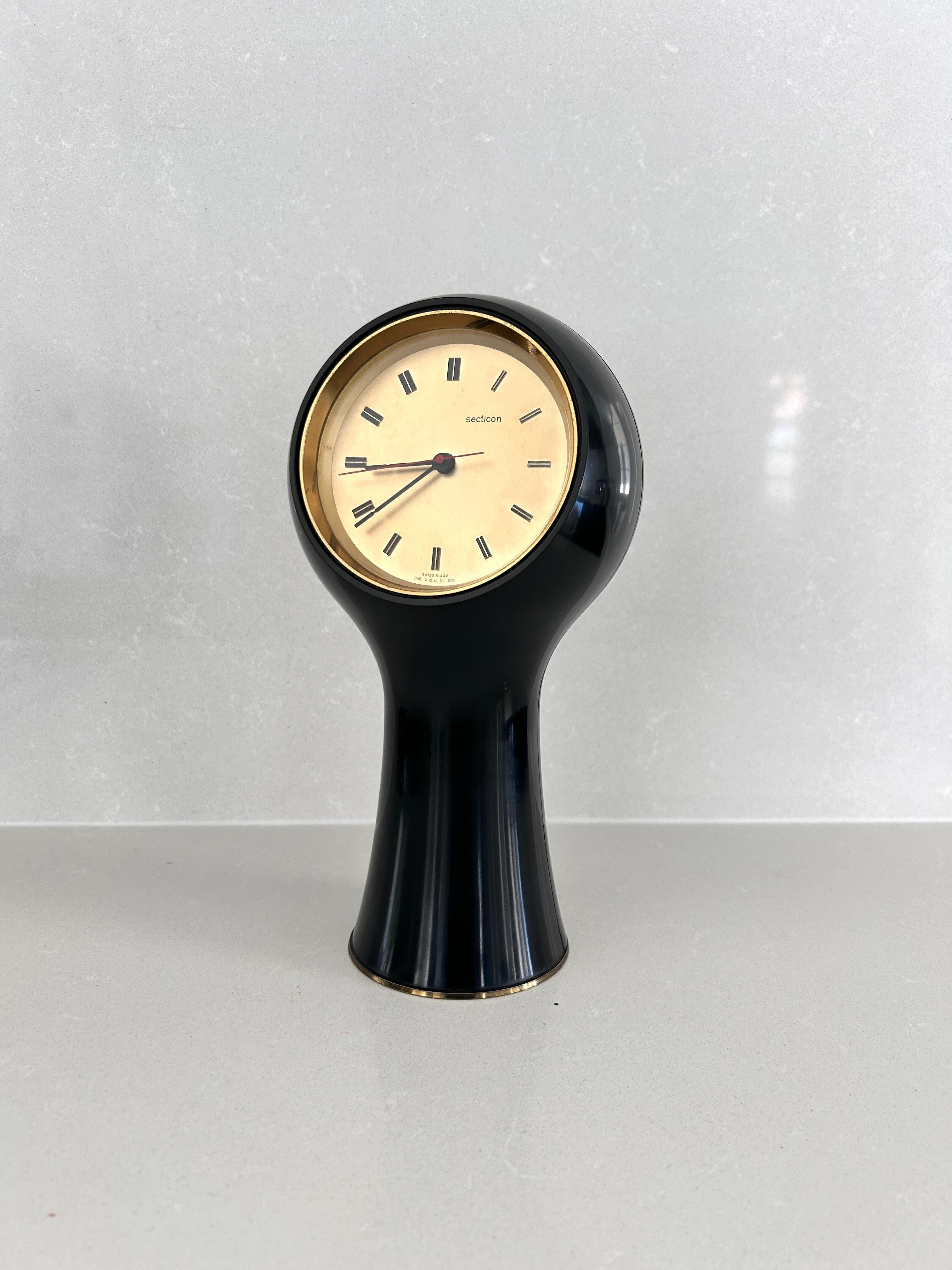 Orologio da tavolo disegnato da Angelo Mangiarotti e Bruno Morassutti nel 1956 per l’azienda svizzera Le Porte-Echappement Universel.  

Struttura in plastica nera, movimento a batteria.