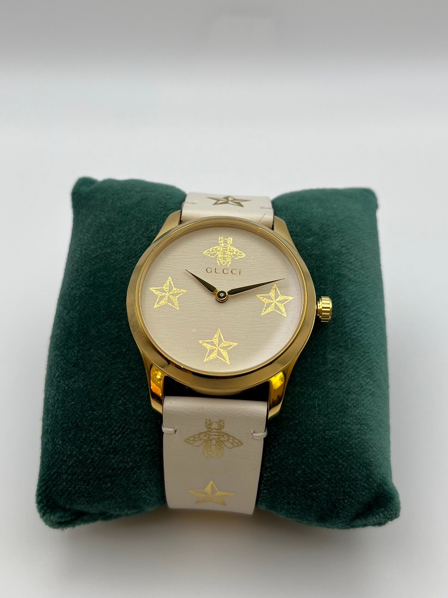 Orologio Gucci con quadrante e cinturino in pelle beige decorata con simboli (stelle ed api) in oro. La casse è placcata in oro e misura 38 millimetri di diametro. Orologio swiss made, nuovo e con la scatola originale.