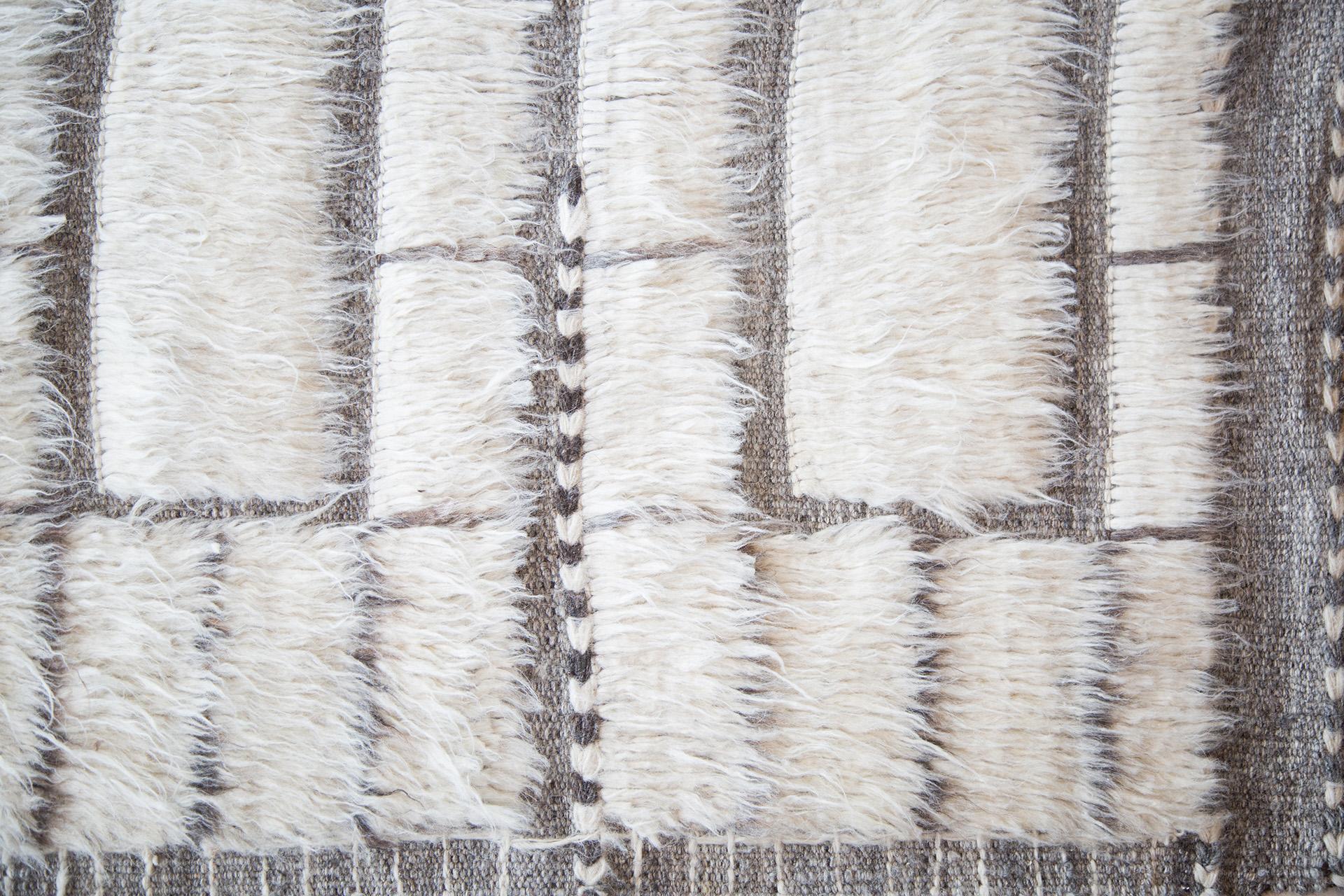 Oroshi is named after Japanese winds. This piece from Mehraban's Haute Bohemian collection has timeless checkered design elements and natural earth tones with the perfect shade of ivory shag and natural taupe weave. Oroshi is also bordered with