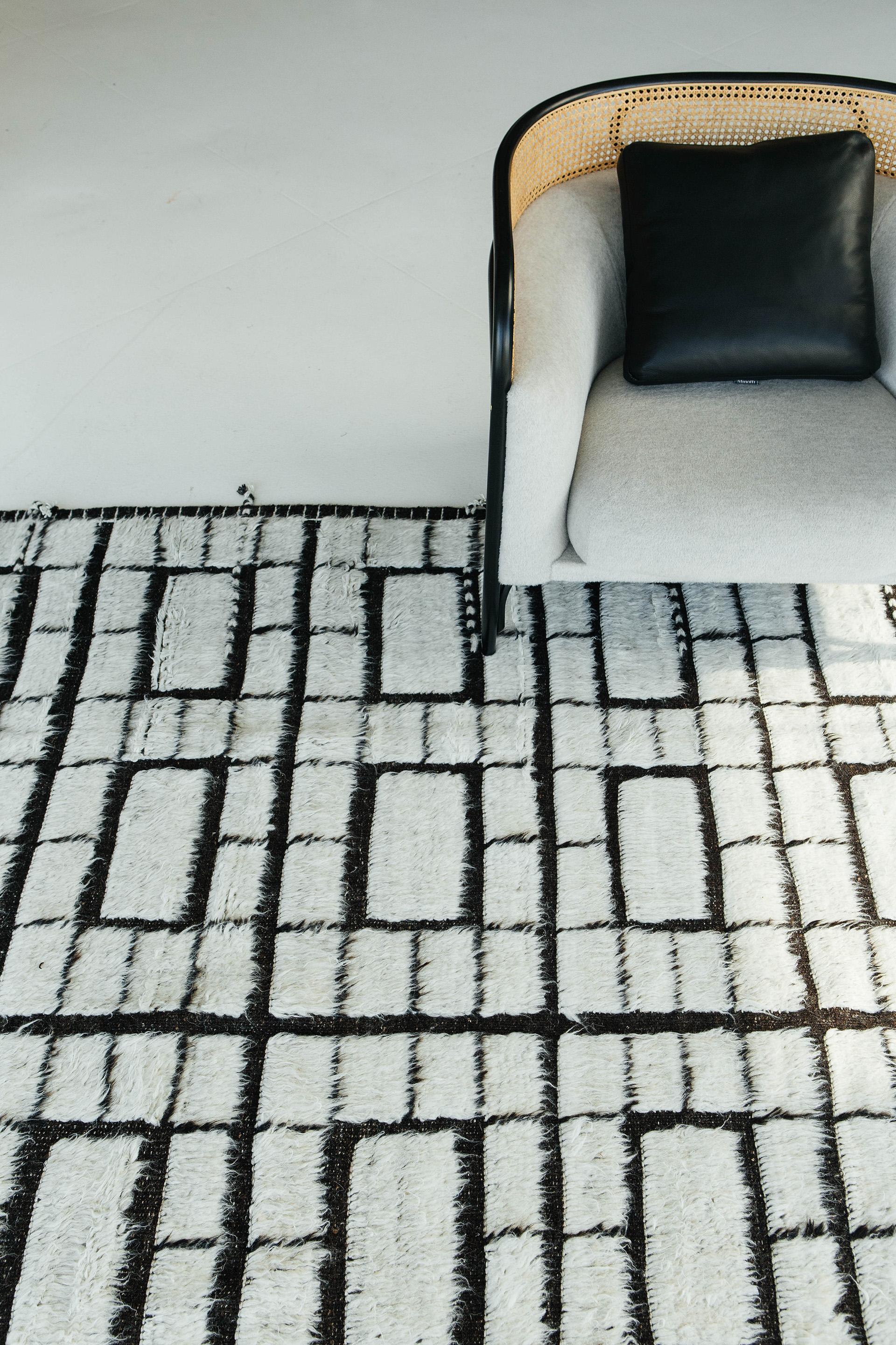Oroshi is named after strong Japanese winds. This piece from Mehraban's Haute Bohemian collection has timeless checkered design elements and natural earth tones with the perfect shade of white shag and black flat-weave. Oroshi is also bordered with