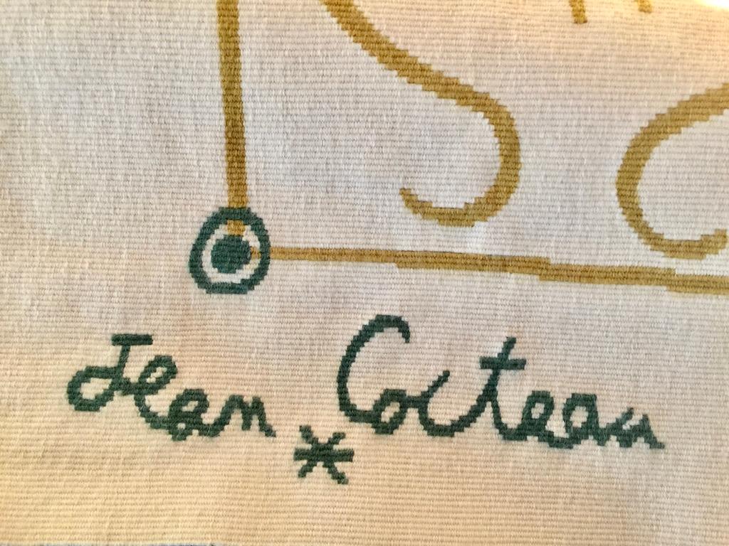 Charming composition of a green-eyed, golden haired lyre player and his instrument woven in wool in dark gold on cream ground, with deep green detailing and woven signature and logo. The reverse with Aubusson label 'Carton de Jean Cocteau', and