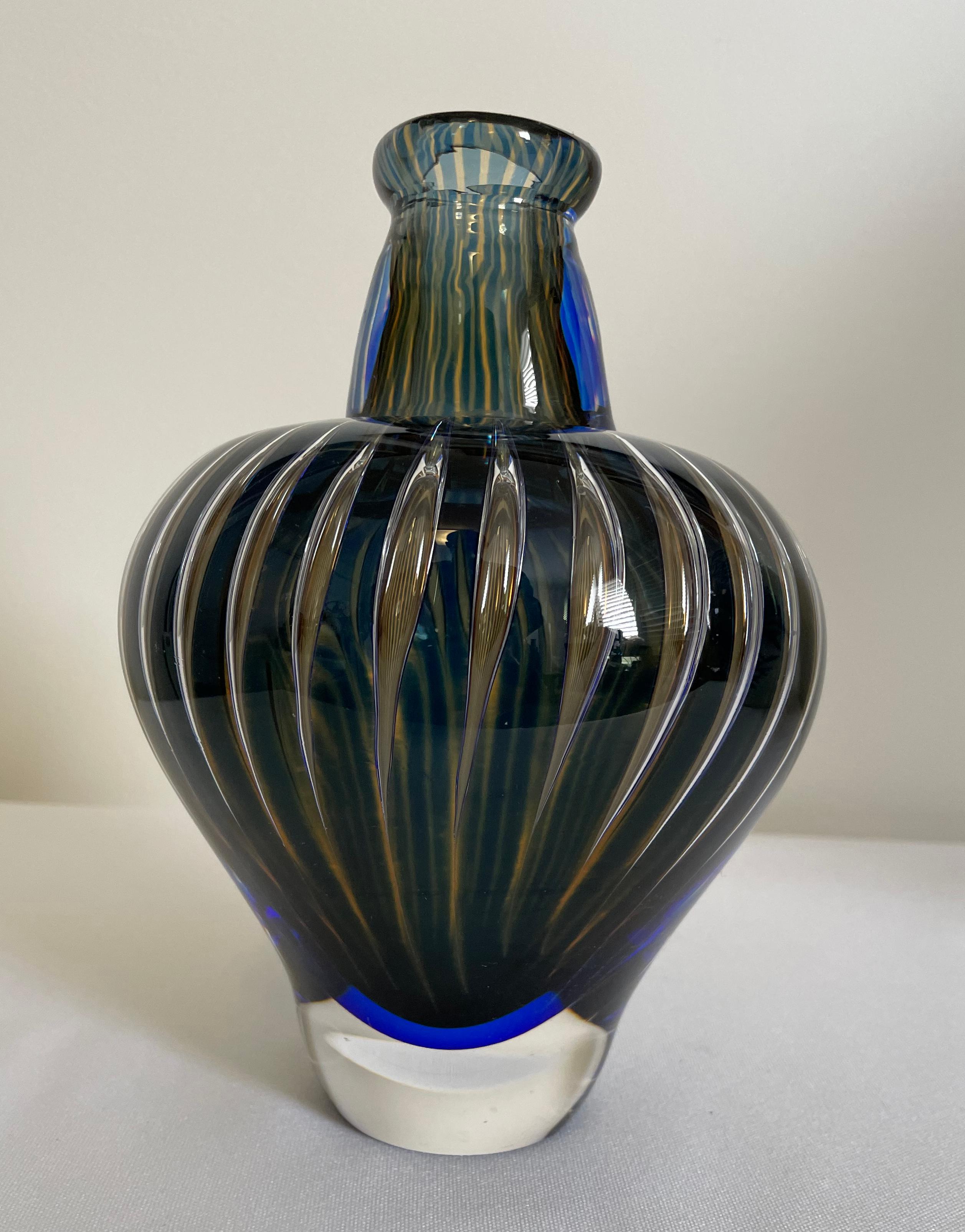 Orrefors Ariel Vase by Edvin Ohrstrom , Sweden, circa 1950.

A thick-walled bottle form with raised asymmetrical rim on a colorless body internally decorated with vertical blue stripes, inscribed on base Orrefors Ariel 3500 Edvin Ohrstrom

Edvin