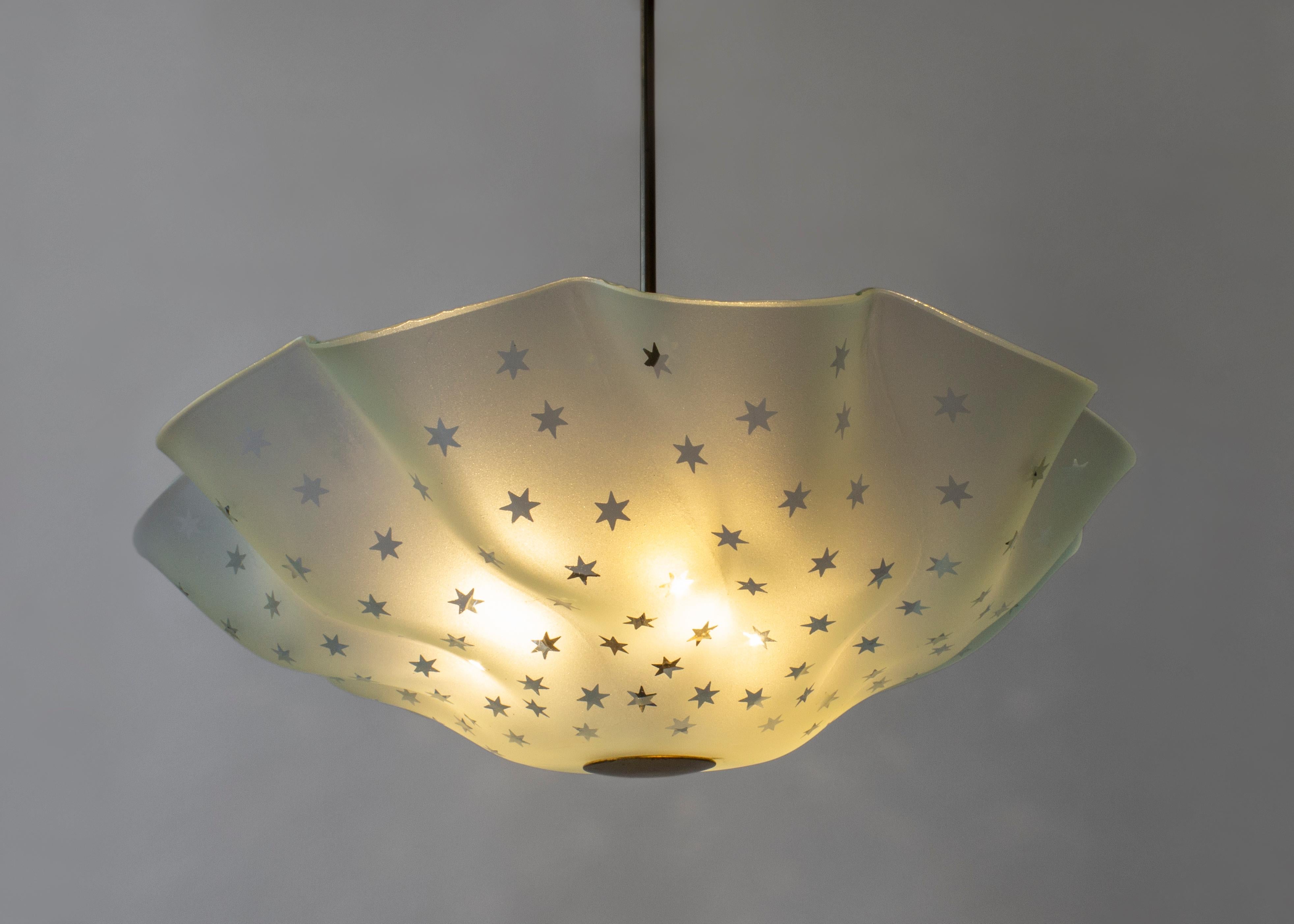 An incredibly rare and beautiful model. The patinated brass canopy and hanging-rod, above an ethereal blue/green frosted glass diffuser, sumptuously folded and adorned in a spray of transparent stars. 

The height can easily be adjusted. The