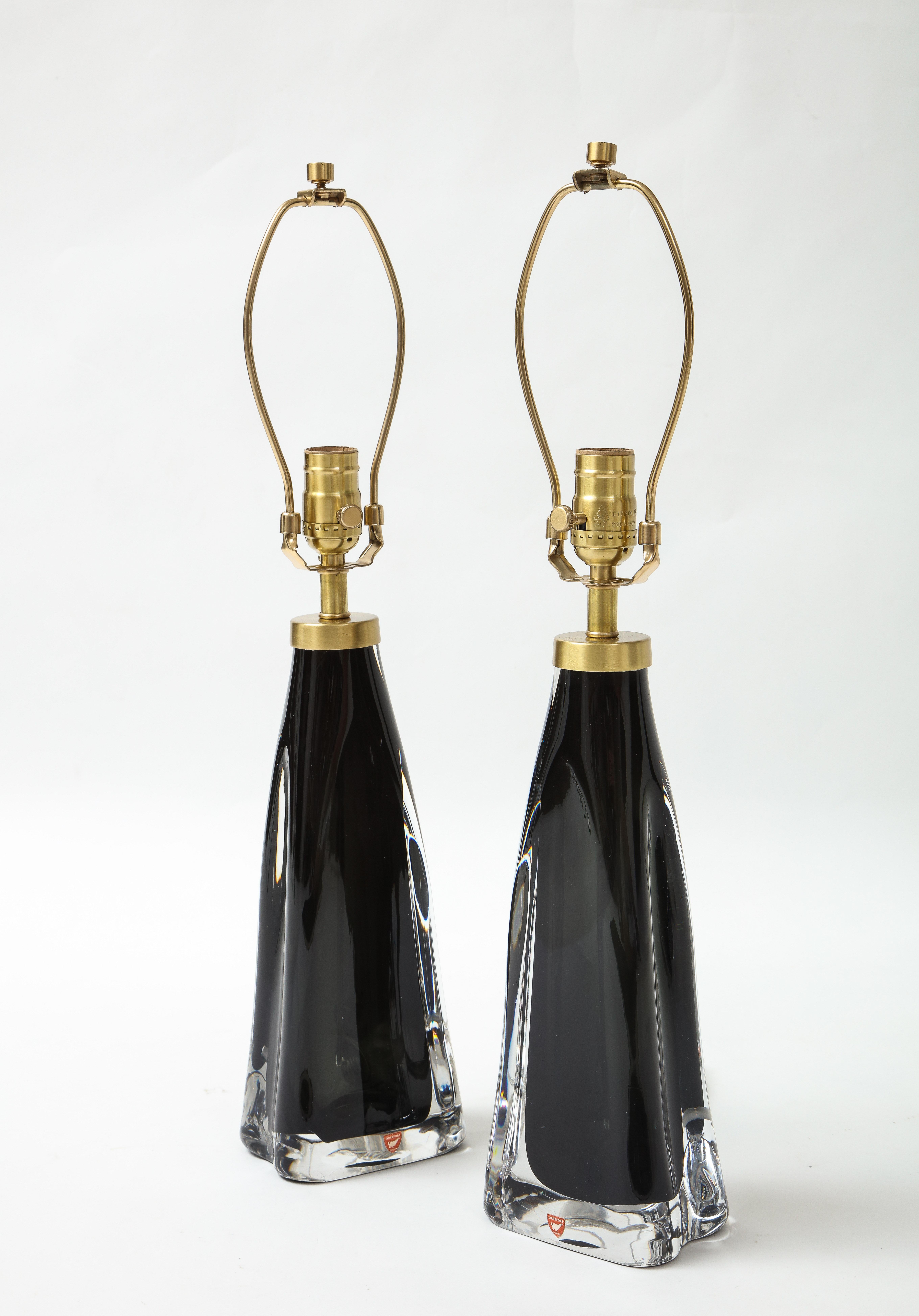 Rare pair of Orrefors black crystal lamps cased in clear crystal, this is a rare color and is seldom seen. Rewired for use in the USA with brass fittings, 100W max.