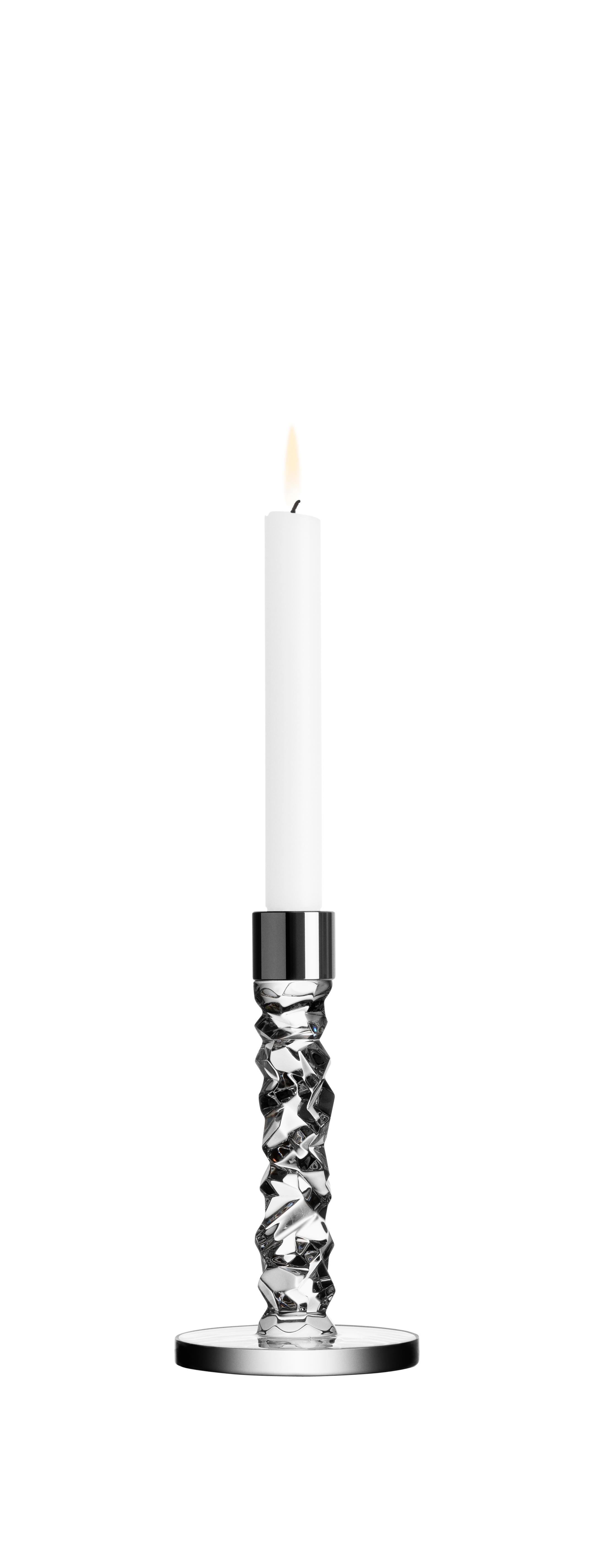 Die Carat Kollektion basiert auf einer zeitgenössischen Interpretation des traditionellen geschliffenen Glases, für das Orrefors weltweit bekannt ist. Die unregelmäßige Geometrie erzeugt schöne Lichtreflexe im Kristall. Der kleine Kerzenständer aus