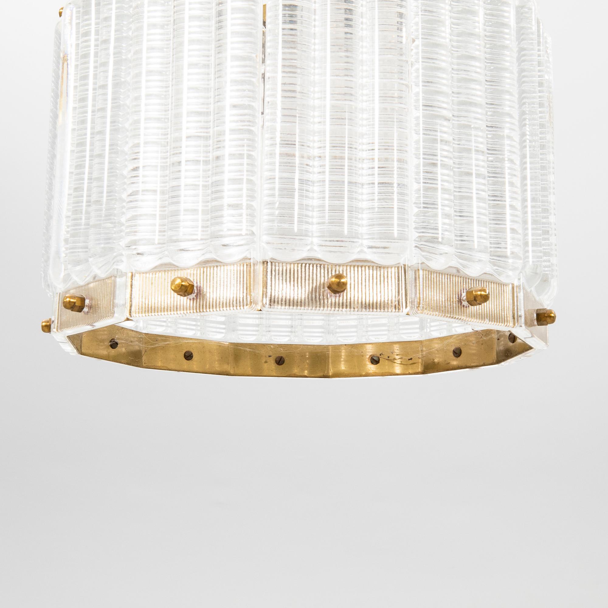 Lampada da soffitto Orrefors Ottone e vetro made in  Svezia intorno a  1960.
È realizzato in ottone e la lunghezza del vetro piegato può essere regolata.
Buono stato

