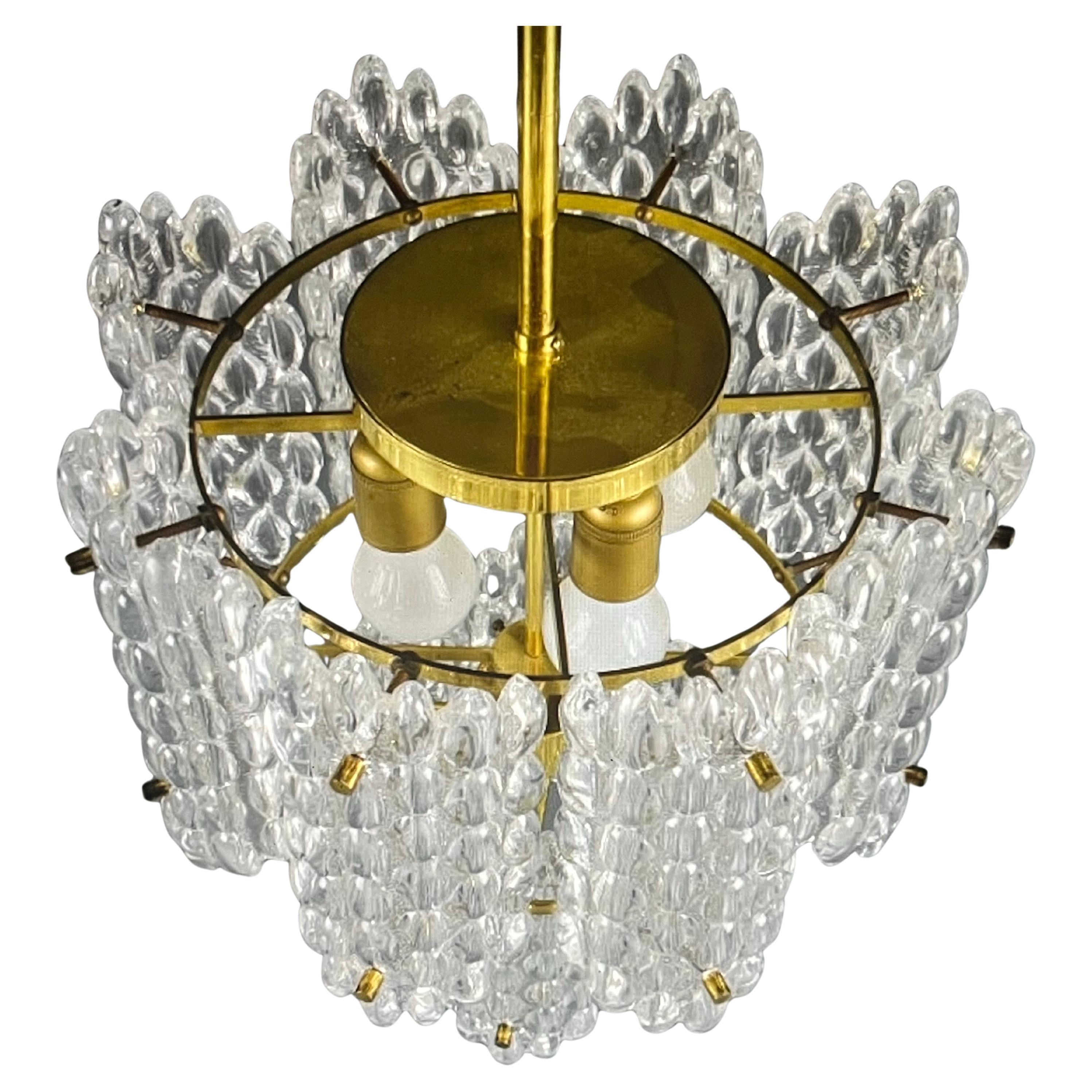 2 tier Orrefors chandelier with several individual glass panels on a brass frame .
four Edison sockets.



