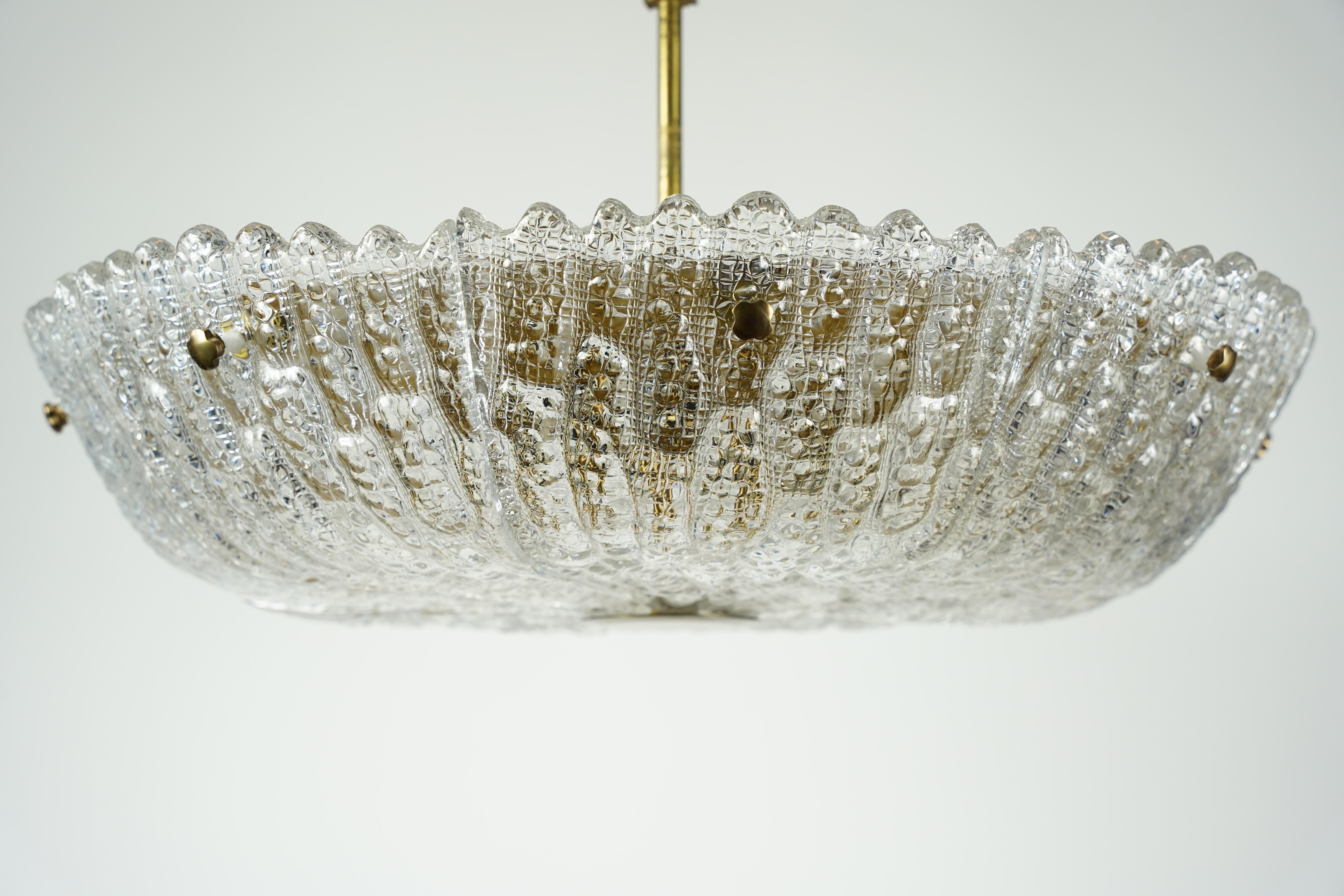 Lustre conçu par Carl Fagerlund pour Orrefors sur une lourde monture en laiton fabriquée à la main. Verre de cristal suédois épais sur une monture en laiton fabriquée à la main, huit douilles Edison.

Une livraison directe peut être organisée dans