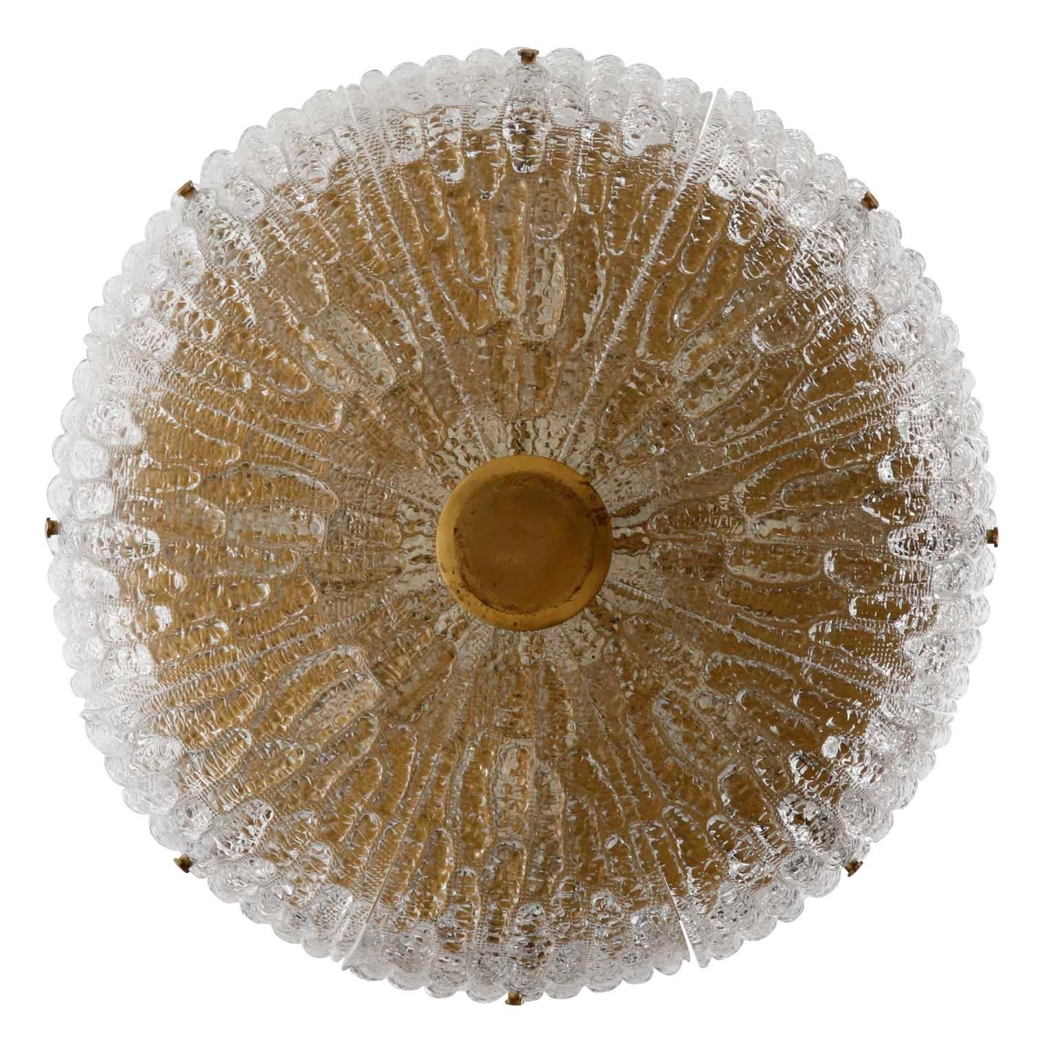 A large Swedish pressed glass and brass light fixture designed by Carl Fagerlund for Orrefors, manufactured in midcentury, circa 1960 (late 1950s-early 1960s).
Eight textured glass elements are mounted with brass bolts on a solid brass frame. There