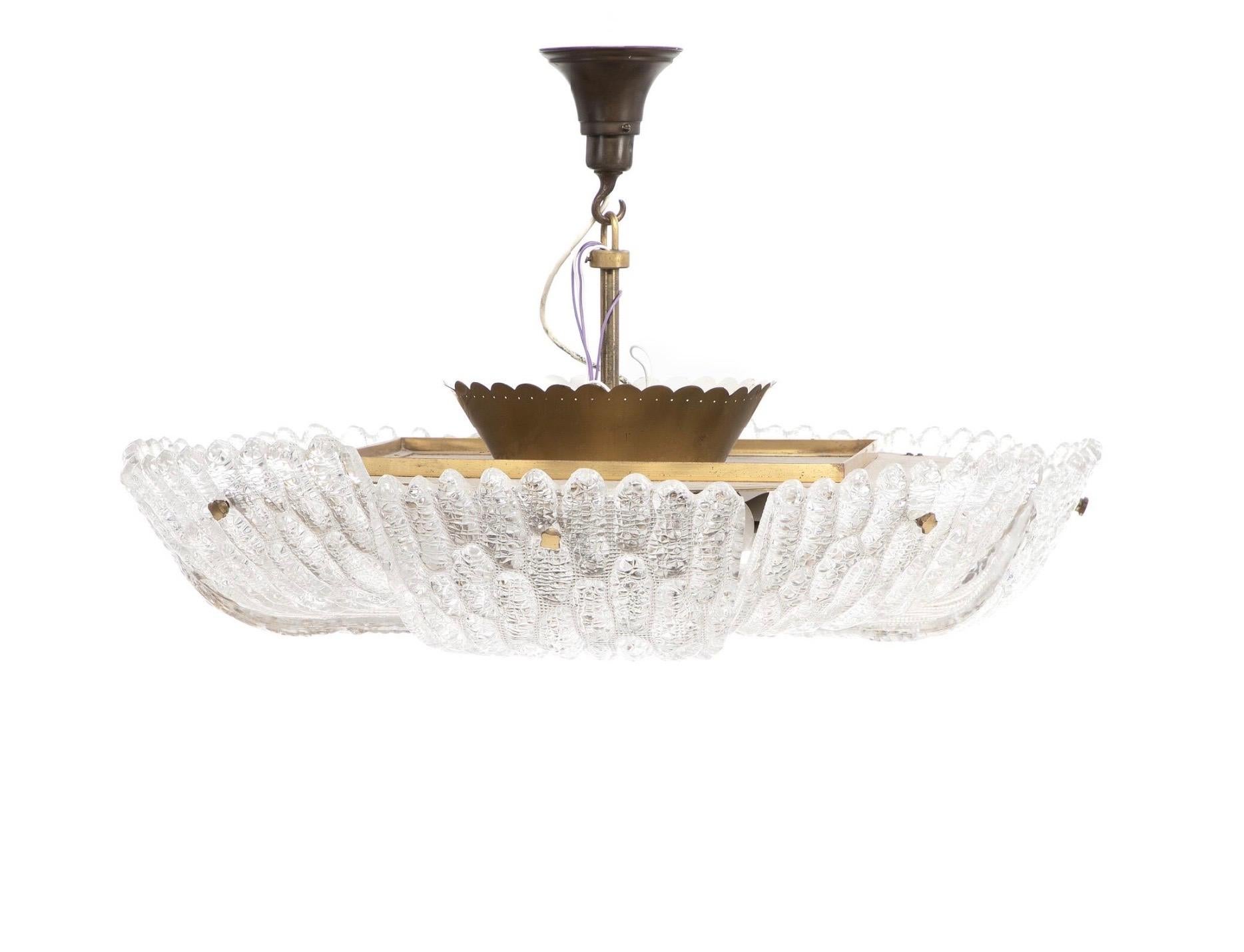 Orrefors chandelier 1950 Sweden.
Eight pie shaped crocodile pattern glass slices together make up the diffuser with a large flat round brass piece in the center that supports the glass each glass is held in place with a single brass finial.

This is