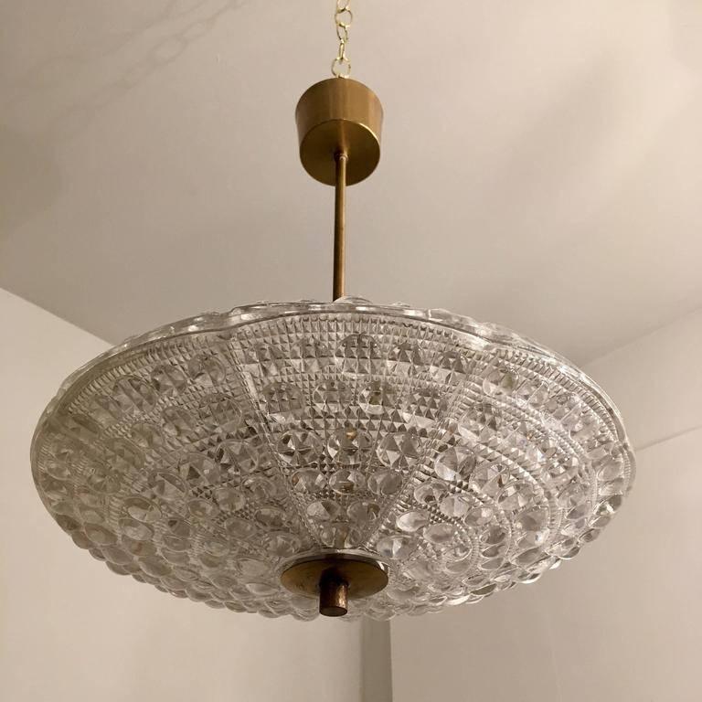 An original, 1950s Swedish pendant chandelier comprised of two large textured bubbled crystal round shades and golden brass fixtures. Newly rewired . 6 ea. candelabra base bulbs. 25 - 40 watt bulbs. 240 max.