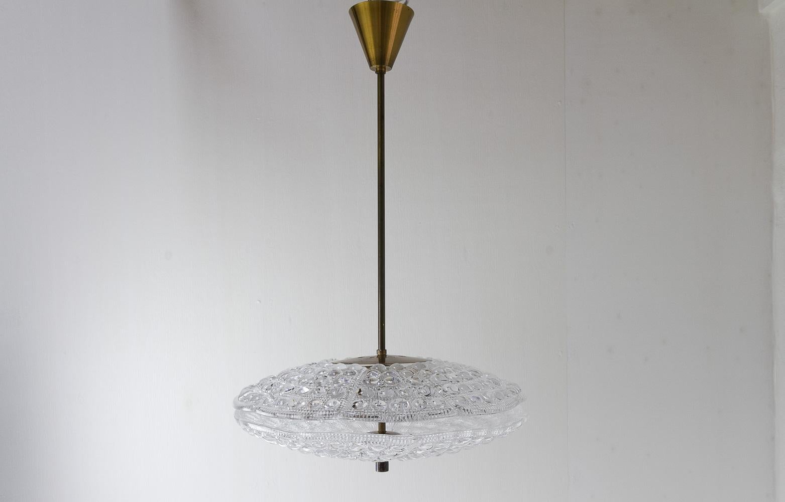 Orrefors Crystal and Brass Ceiling Pendant by Fagerlund for Lyfa, 1960s.
Scandinavian Mid-Century Modern Brass and crystal glass chandelier. Produced by Lyfa Denmark, designed by Carl Fagerlund and the two thick textured crystal glass shades are