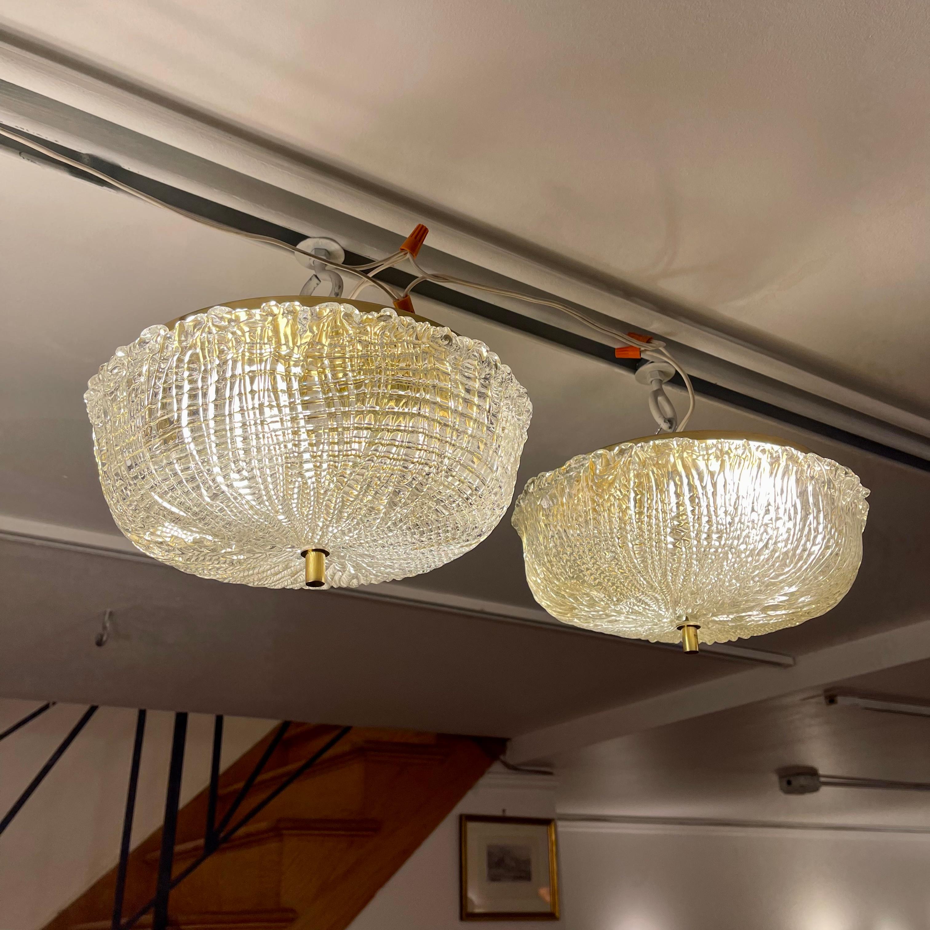 Hand cast crystal shades diffuse light beautifully. A brass ceiling plate mounts two standard medium base bulbs and reflects a rich golden hue back through the cast shades.