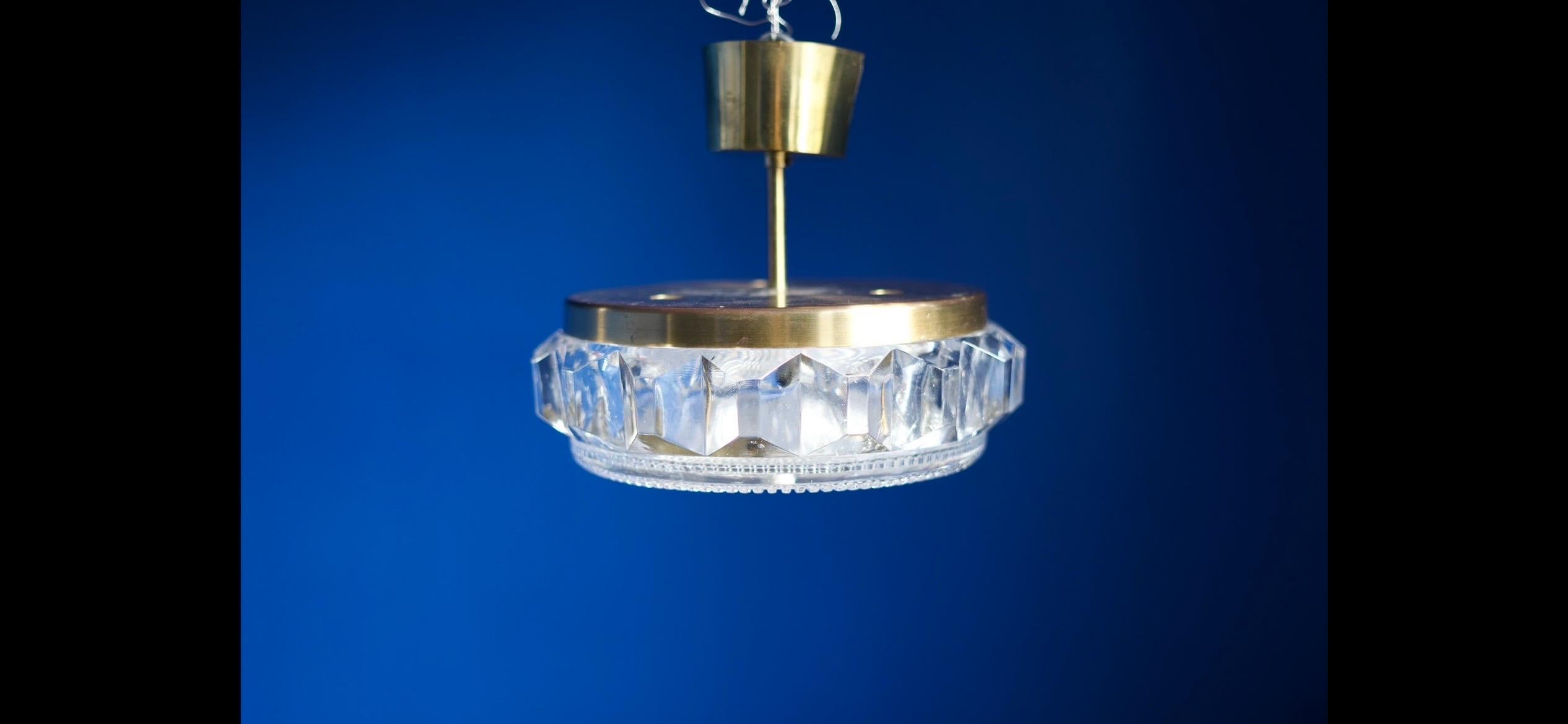 Swedish Orrefors pendant from the 1960s by Carl Fagerlund,
Thick bottom glass plate held by a brass  finial in the bottom middle.
Three candelabra sockets.

Rewired.

