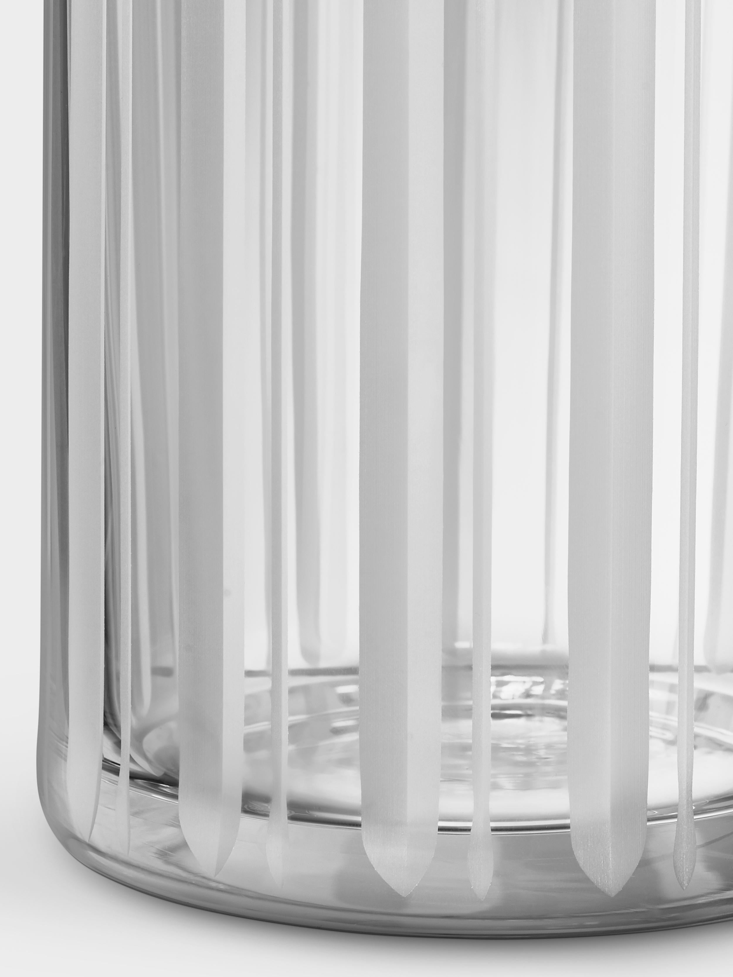 The tall cylinder vase with a stripe motif in the Cut In Number collection from Orrefors is ideal for long stem flowers. The satin finished cuts on the vase beautifully emphasize the transparency of the clear crystal. Designed by Ingegerd Råman.
