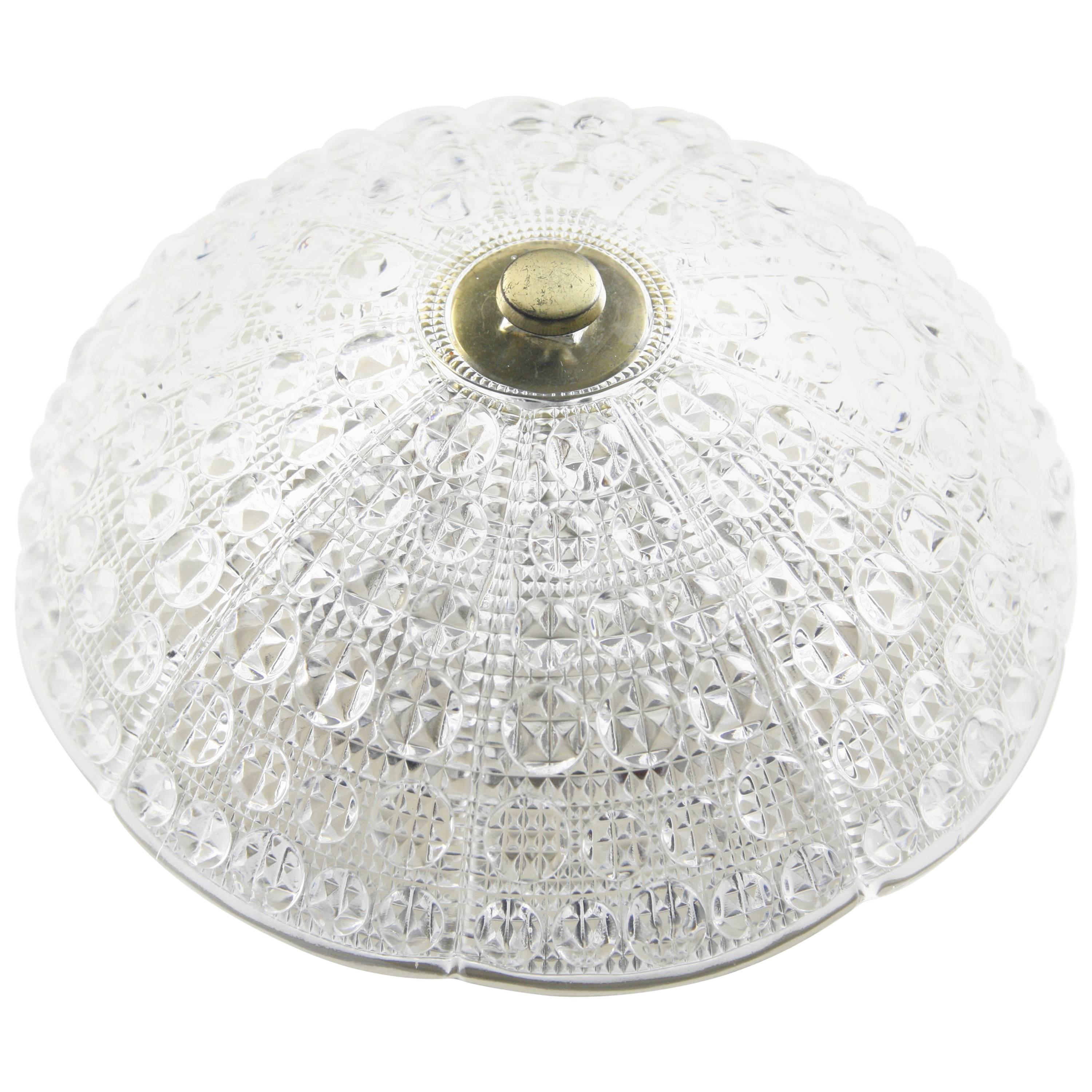 Orrefors flush mount ceiling plate is cream white metal with six European candelabra sockets the shade is a dome shaped pressed bubble crystal and details in brass.

 