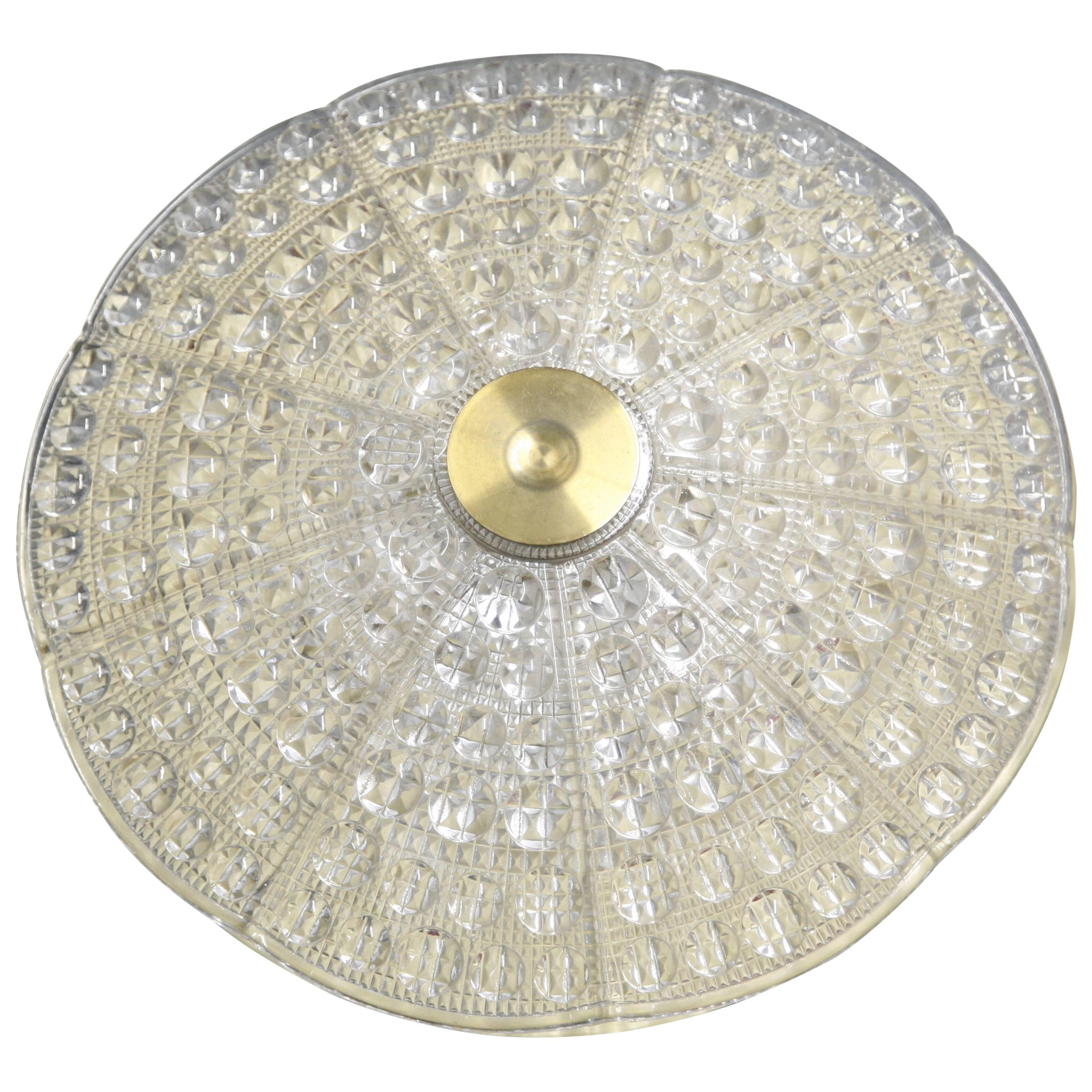 Orrefors Flushmount, crystal diffuser on a brass frame, 1960, Sweden in all vintage condition with five European candelabra sockets on a brass frame.
The shade is a thick domed cast crystal with a smooth surface with bubble structure designed by
