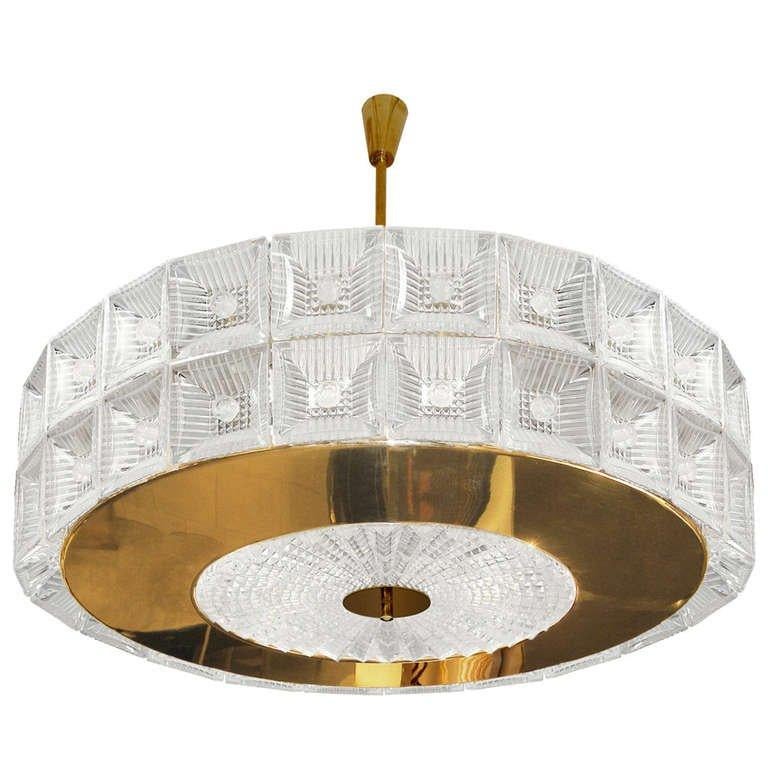 A glass and brass chandelier consisting of multiple pieces of pressed glass around a brass ring with inset glass plate attached to a frame by Cal Fagerlund for Orrefors.

Swedish, Circa 1940's