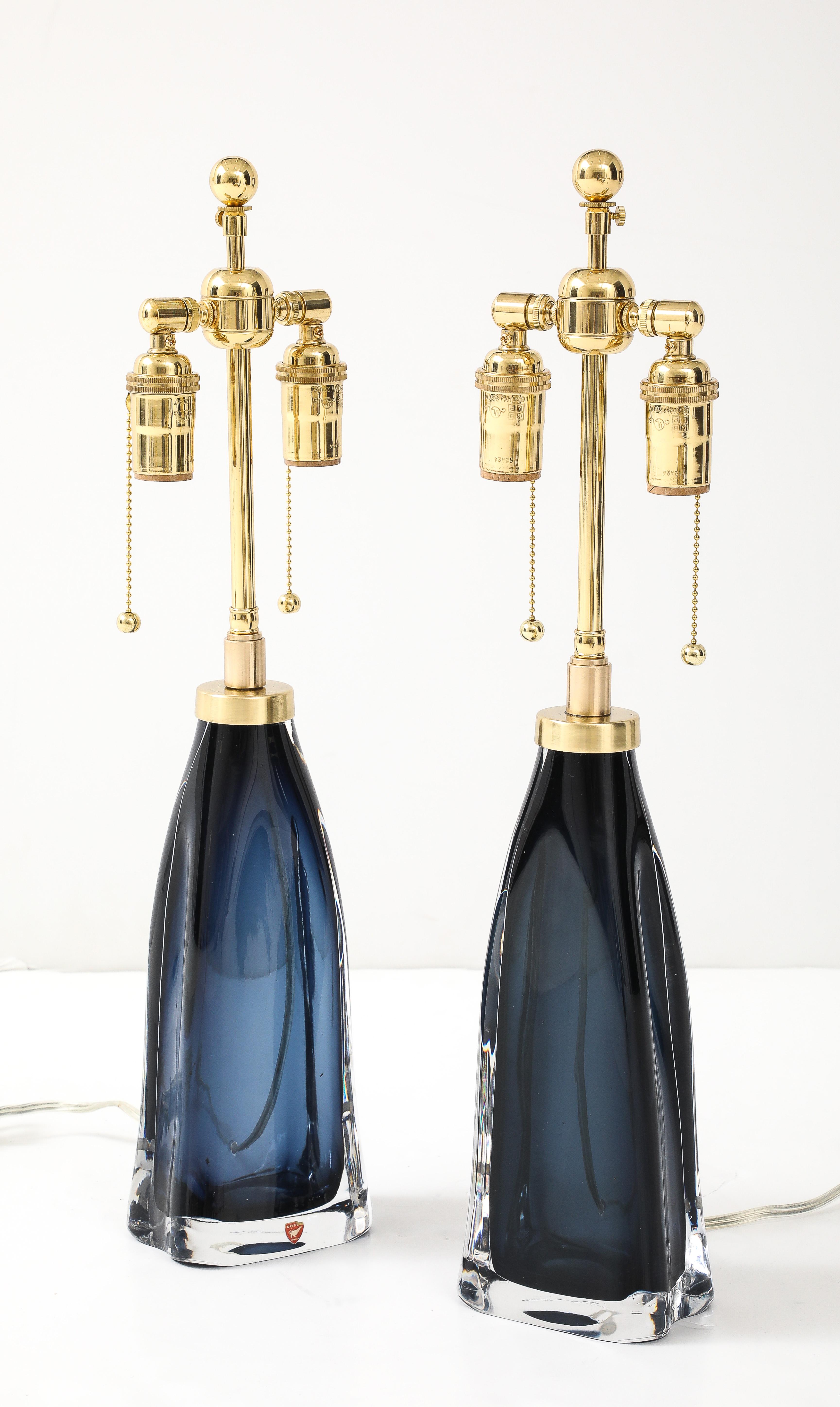 Coppia di lampade Mid-night Blue Crystal degli anni '60 disegnate da Carl Fagerlund per Orrefors.
Le bellissime lampade colorate di blu sono state ricablate di recente con lampade regolabili e lucide.
Doppi cluster in ottone e Corde