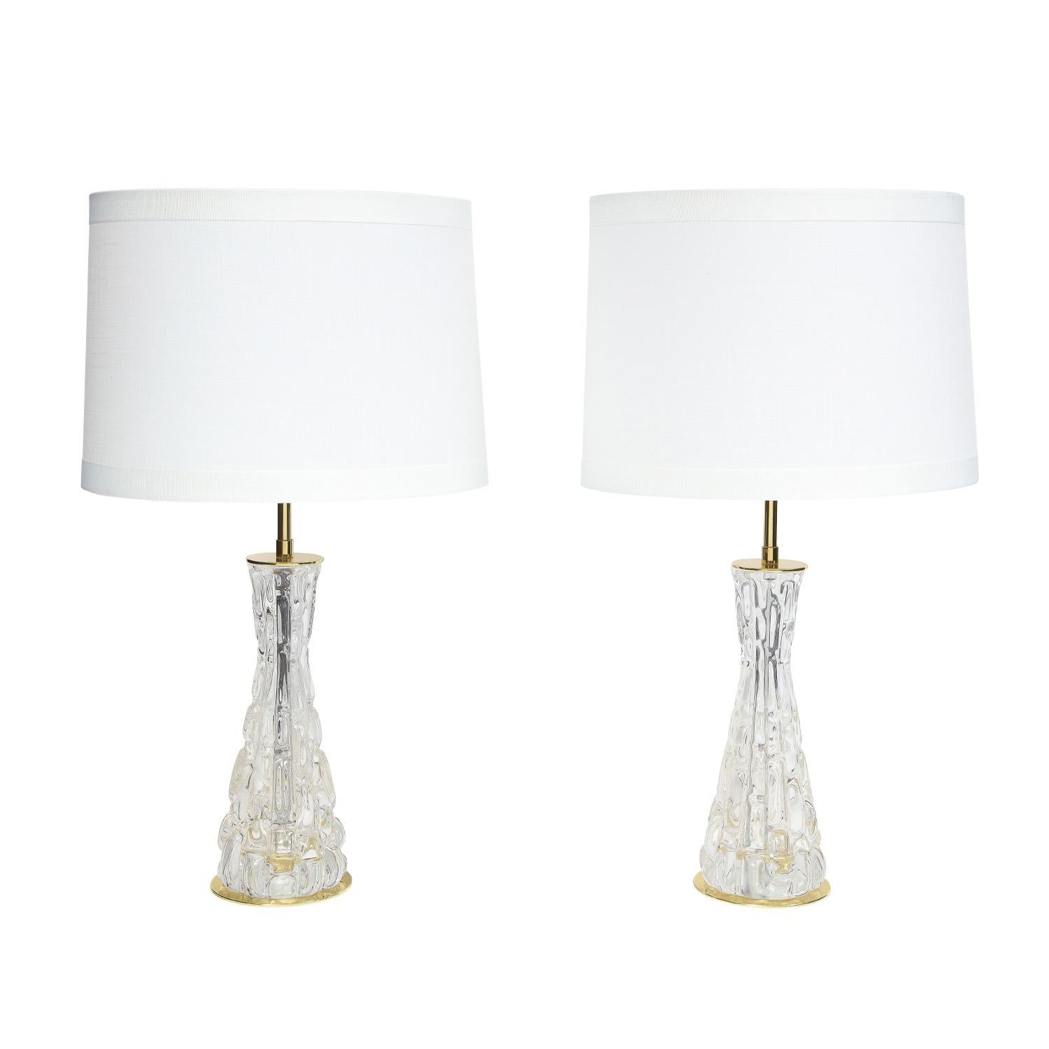 Pair of exquisite table lamps with textured glass by Carl Fagerlund for Orrefors and sold by Hansen Lighting, American 1957. These have been newly rewired and polished and are in like-new condition.

Measures: Diameter: 5 inches 
Height: 23