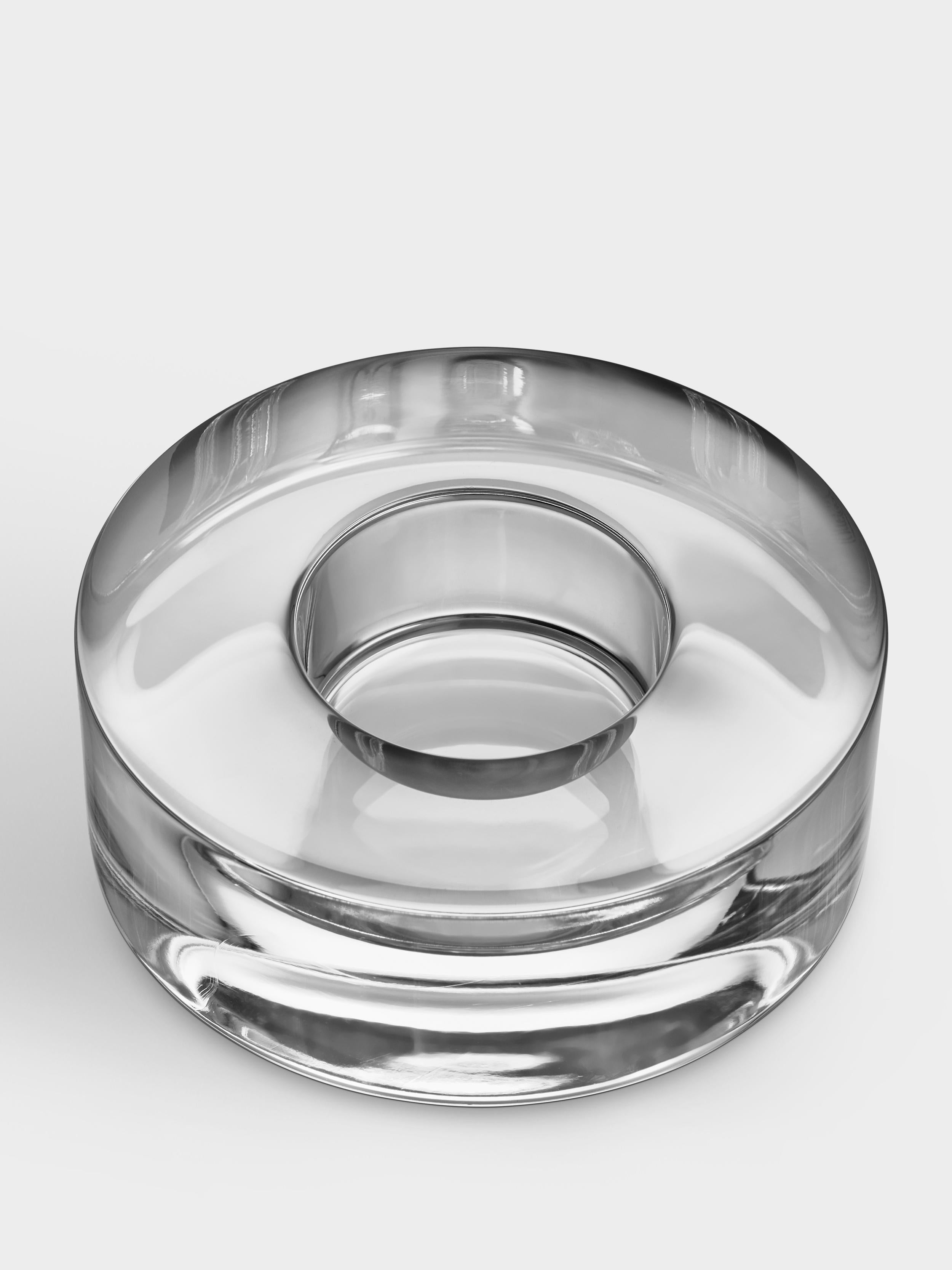 Le petit Puck Votive est un bougeoir, adapté aux bougies chauffe-plat, au design minimaliste qui fait le lien entre les similitudes entre le cristal pur et la glace. Lorsque le produit d'Orrefors a été lancé pour la première fois en 1999, il a