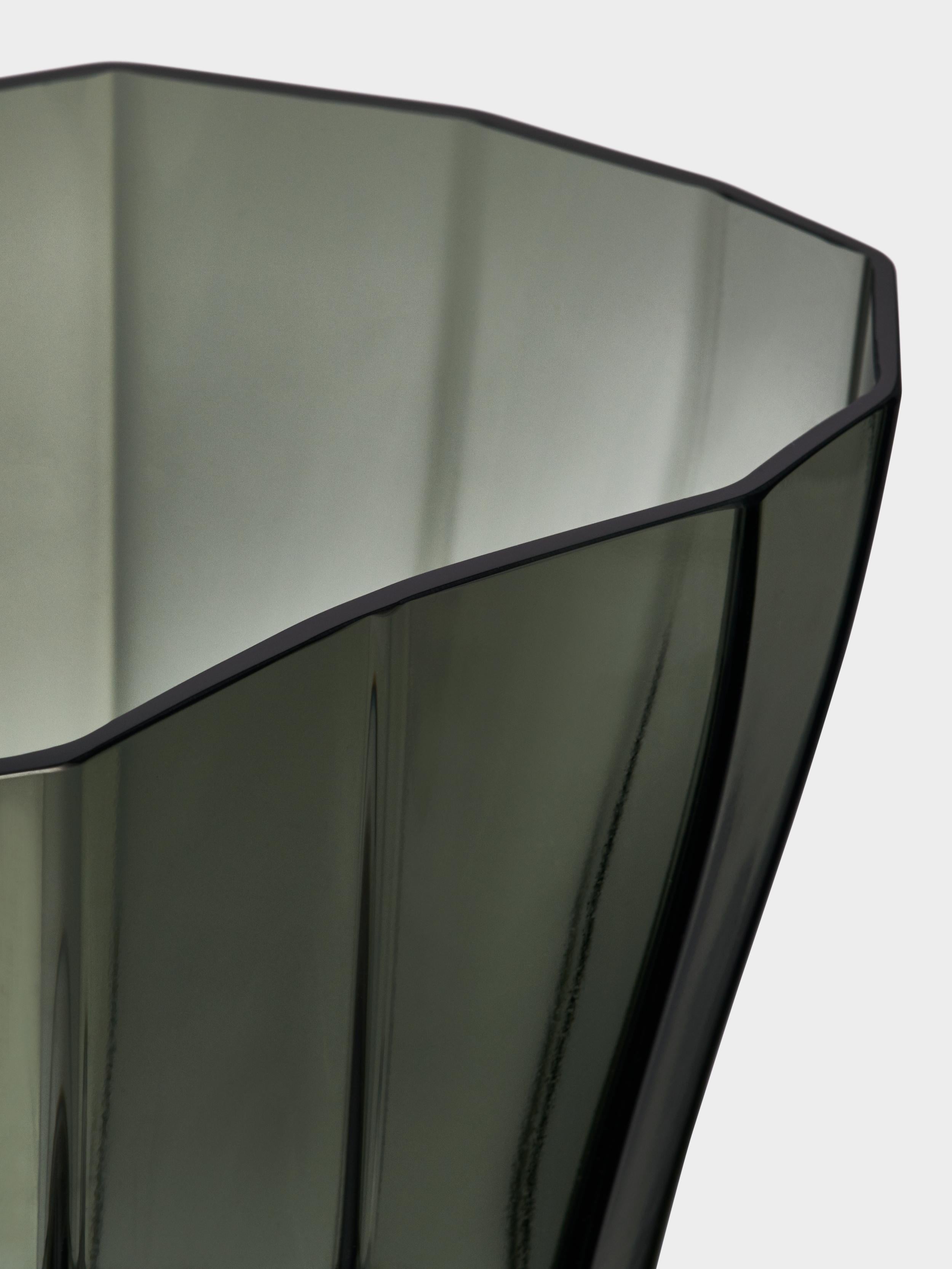 Mit Reed zeigt die schwedische Designerin Monica Förster, wie man durch die Betonung von Falten ein Gefühl von organischer Bewegung erzeugen kann. Ein leises Schwanken in dem massiven, moosgrünen Glas. Die niedrige Reed-Vase eignet sich gut für
