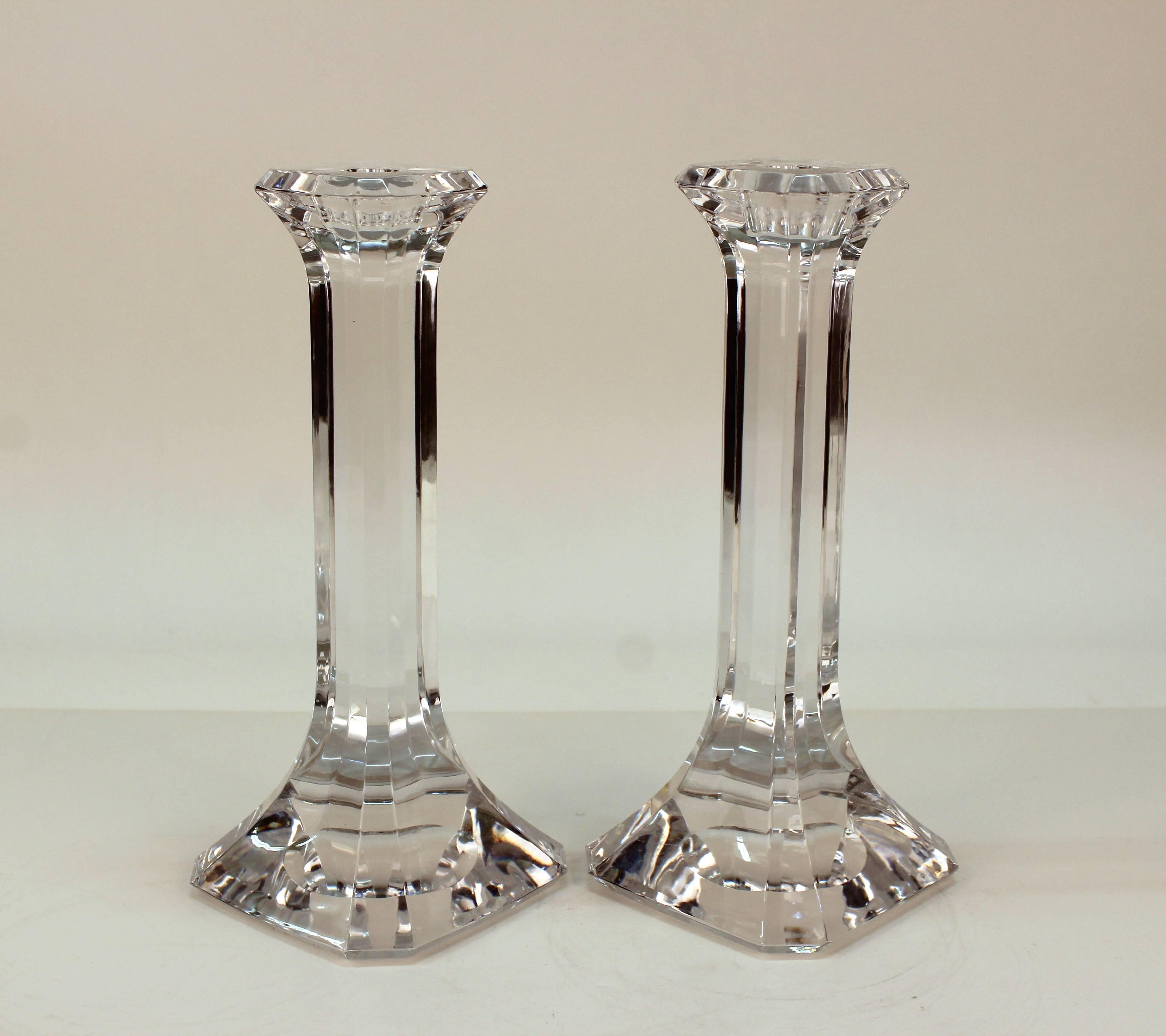 Orrefors Regina candlesticks in clear cut crystal. Features include a faceted column design on square bases. Signed on the bottom. Despite a minor chip to the corner of one candlestick and wear appropriate to use the pair remain in good vintage