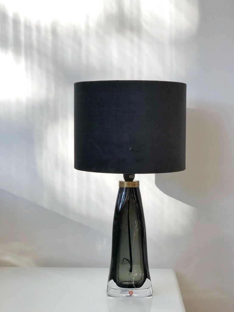 Scandinavian modern pair of Orrefors RD 1323 dark green cased crystal glass table lamps. Heavy glass bases with undulating shape. Model RD1323 was designed by Carl Fagerlund for Orrefors in various colors, this pair is dark green glass, encased in