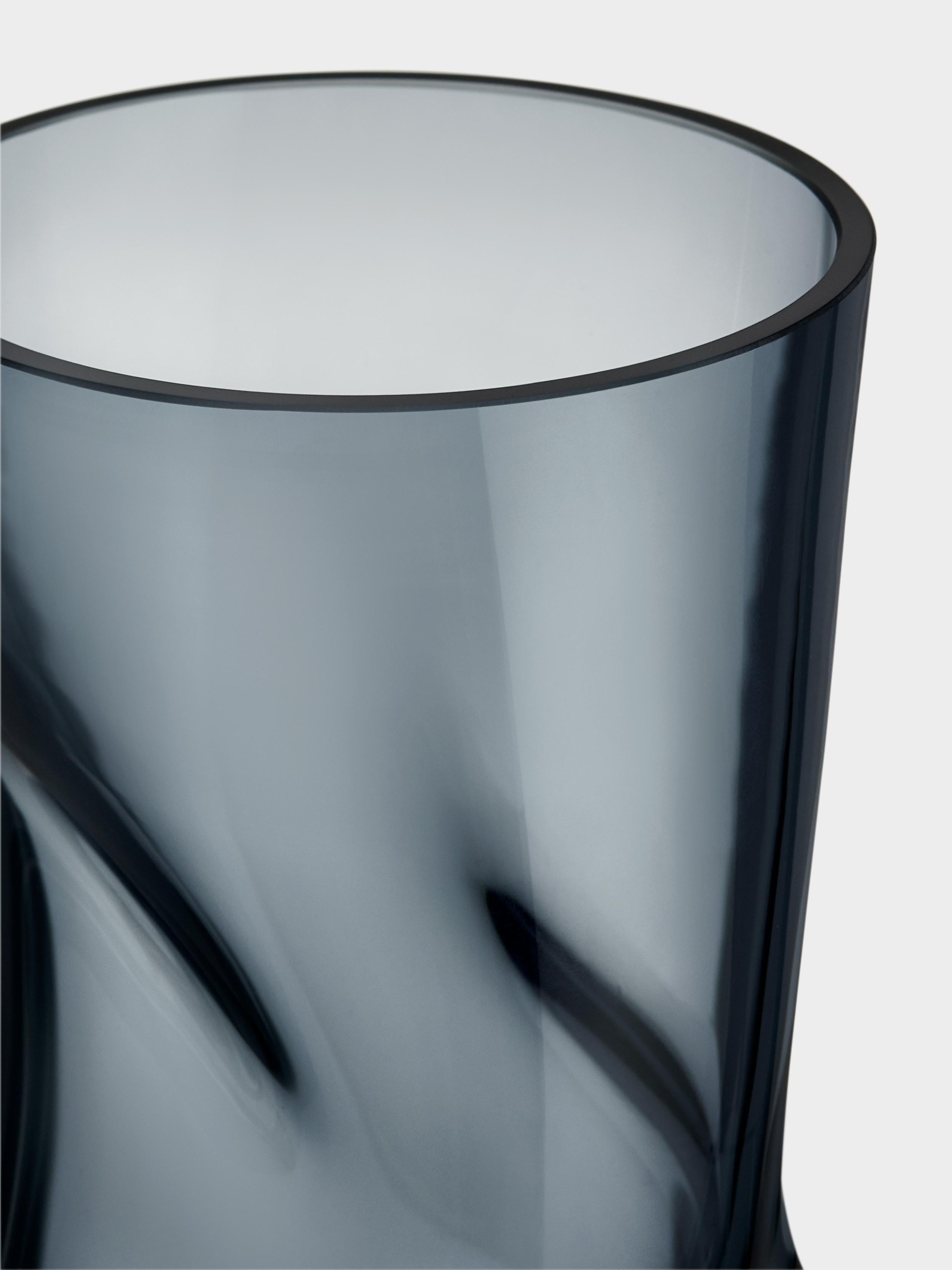 La forma a forma di bocchetta di Squeeze di Orrefors appare diversa da diverse angolazioni, a seconda della sua collocazione. Dopo che il vaso è stato soffiato, e mentre è ancora caldo, viene 