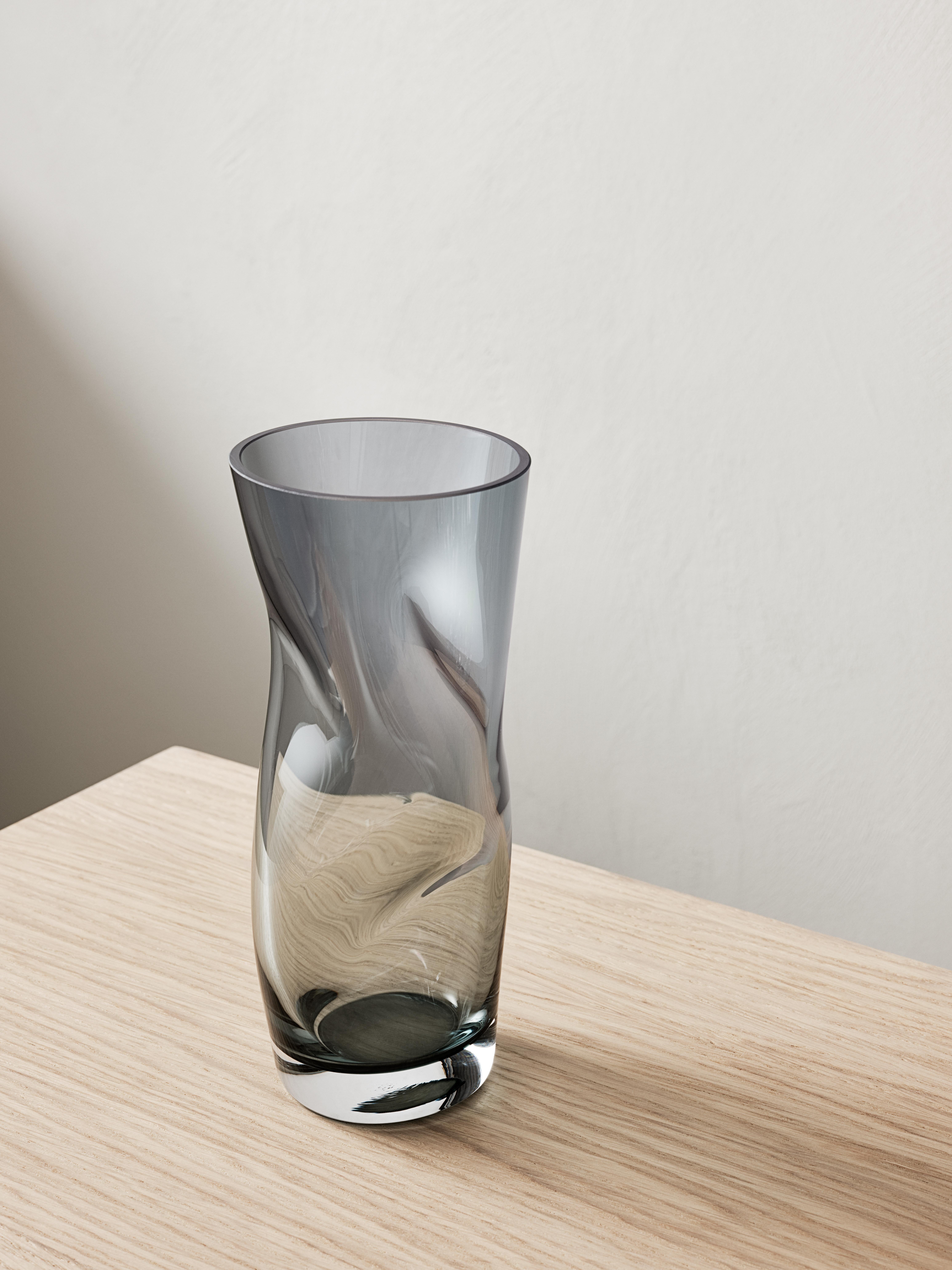 The billowy shape of Squeeze from Orrefors looks different from different angles, depending on its placement. After the vase is blown, and while still hot, it is “squeezed” together by hand in two places. These “squeezes” form a cross inside the