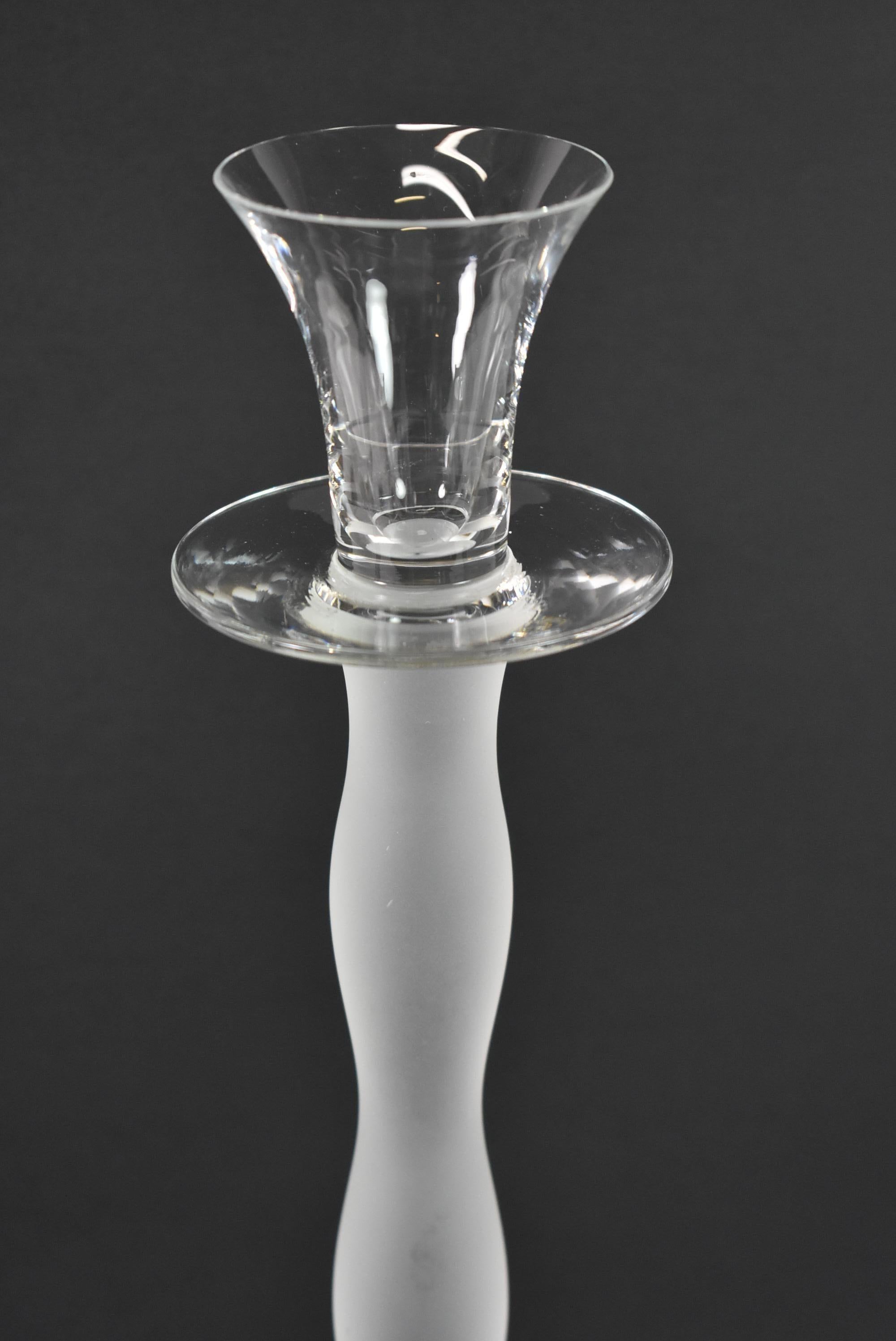 Ensemble de quatre chandeliers en verre de fabrication suédoise par Orrefors. Conçu par Anne Nilssen. Tige givrée avec coupe et base de bougie en verre incolore. Signé. Quatre hauteurs échelonnées. Les plus grands sont 16