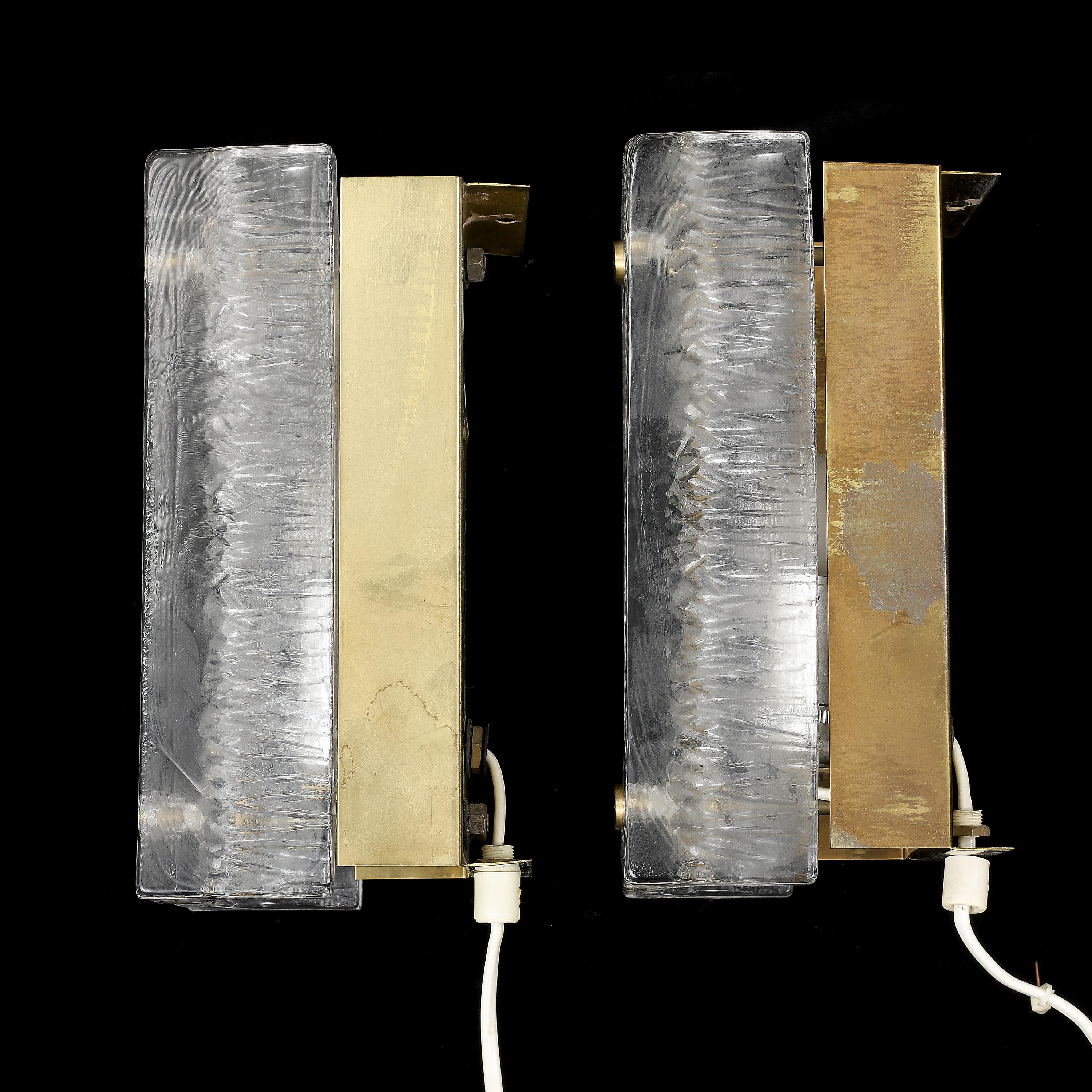 Applique Orrefors  verre moulé et laiton fabriqué en Suède en 1960.
Prix de la paire
en cristal moulé clair, surface extérieure lisse et motif intérieur, les abat-jours en verre reposent sur un cadre en laiton avec des attaches en laiton. Elles